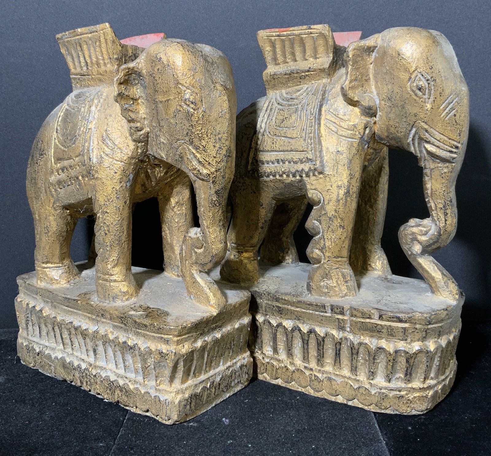 Carved Wooden Elephant Formed Candlestick Holders: Carved wooden elephant candlestick holders. Appear to be vintage. Colored with gilt paint, depicts elephants equipped with saddles atop platforms. Wear is consistent with age and use. Each measures ap