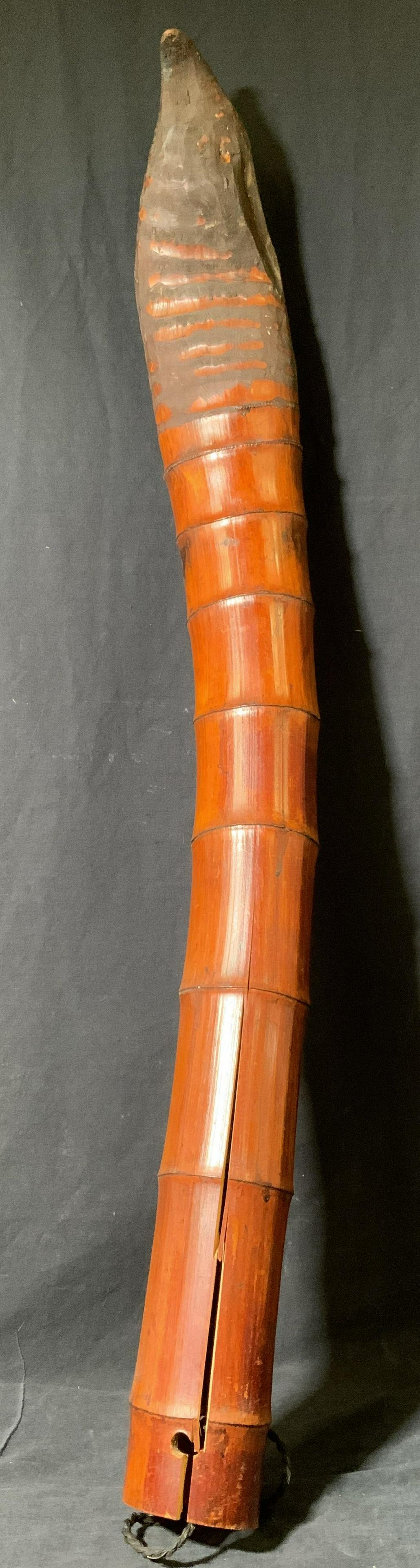 Wooden Didgeridoo instrument Decor: Wooden didgeridoo. One end is affixed with a rope, the other and S-hook, allows for mounting. One end is circular and pointed. Wear is consistent with age and use, the wood has split. Measures approx 