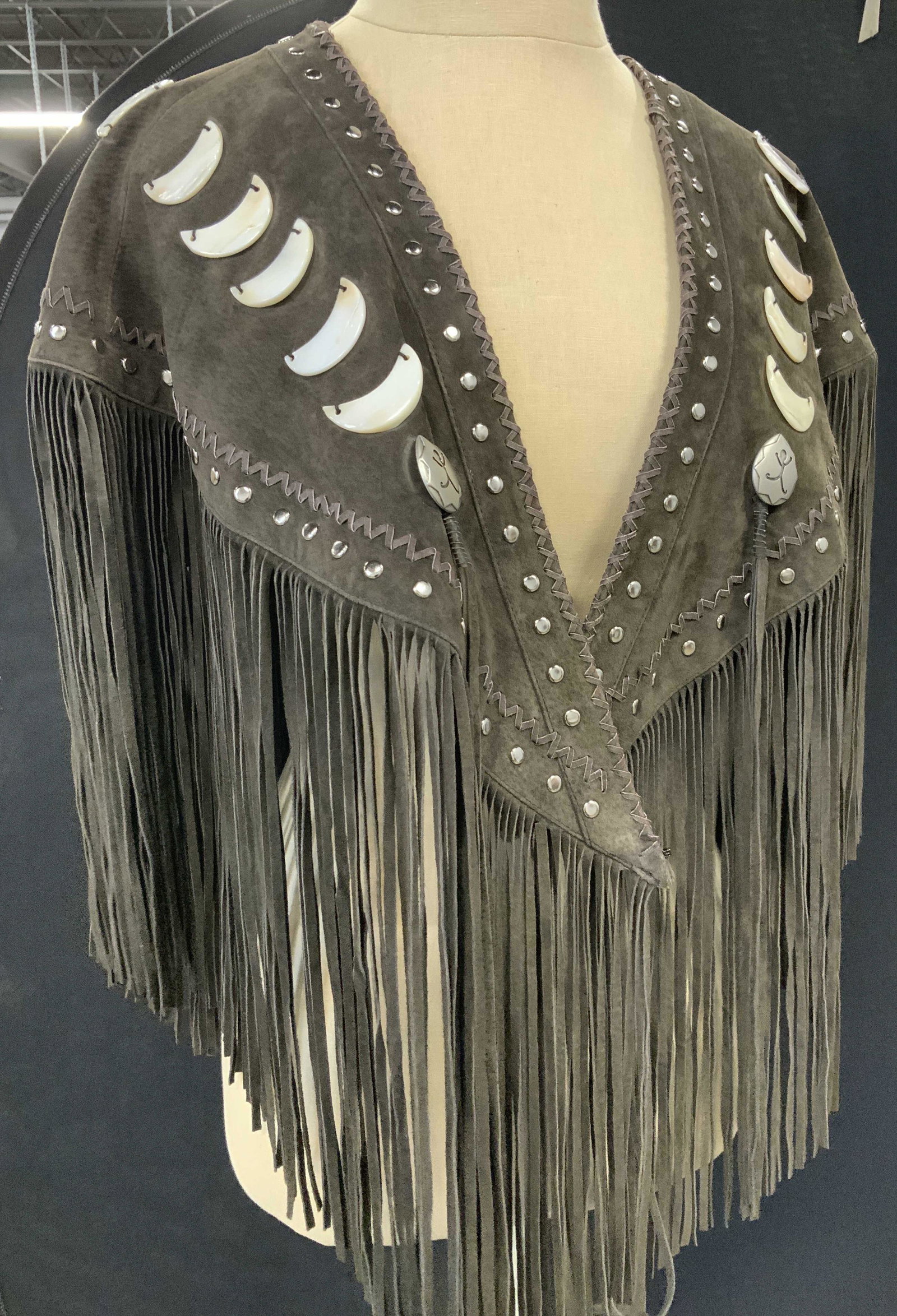 RED CLAY PEOPLE all Suede Tassel & MOP Shawl: Hand crafted brown suede shawl, weighted garment is triangular shape and embellished with Half Moon Mother of Pearl beads ( app 2 x 3/4 in.) and marked with Designer Logo- Embroidered Red Clay People 