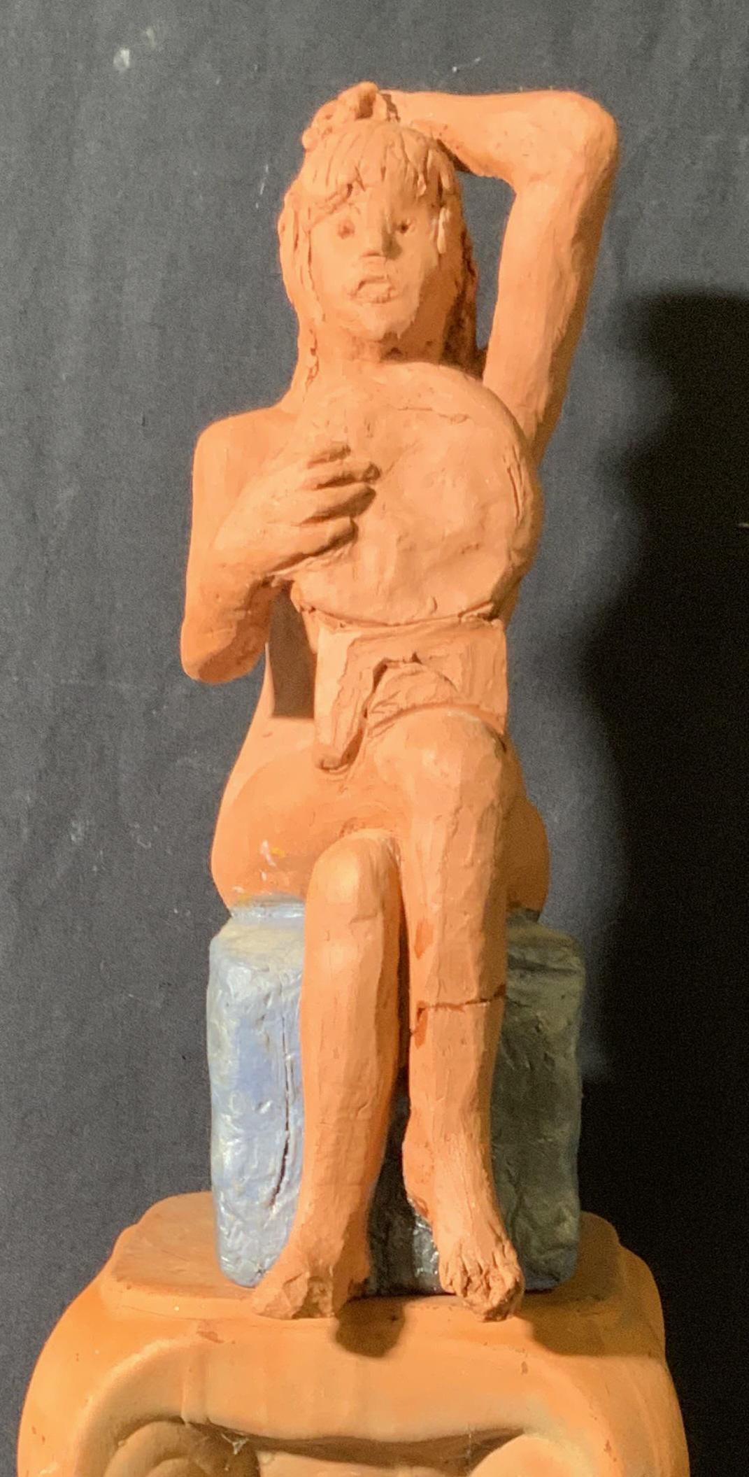 Handmade Female Nude Clay Figural W Pedestal: A handmade clay figural depicting a nude woman observing herself in a mirror. She sits atop a hand painted metallic gray hued block. The piece comes with a terracotta hued ceramic pedestal / column. P