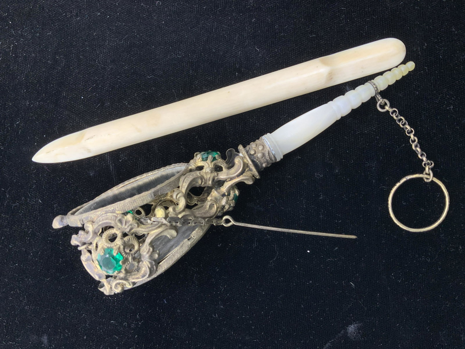 Antique Victorian Tussie Mussie Mirror with MOP: Mirrored Tussie Mussie With carved Mother of Pearl handle, possibly French with openwork Metal Ormolu Scroll motif. Adorned by Emerald green rhinestones, and finger ring & pin chain. Double sided mirr