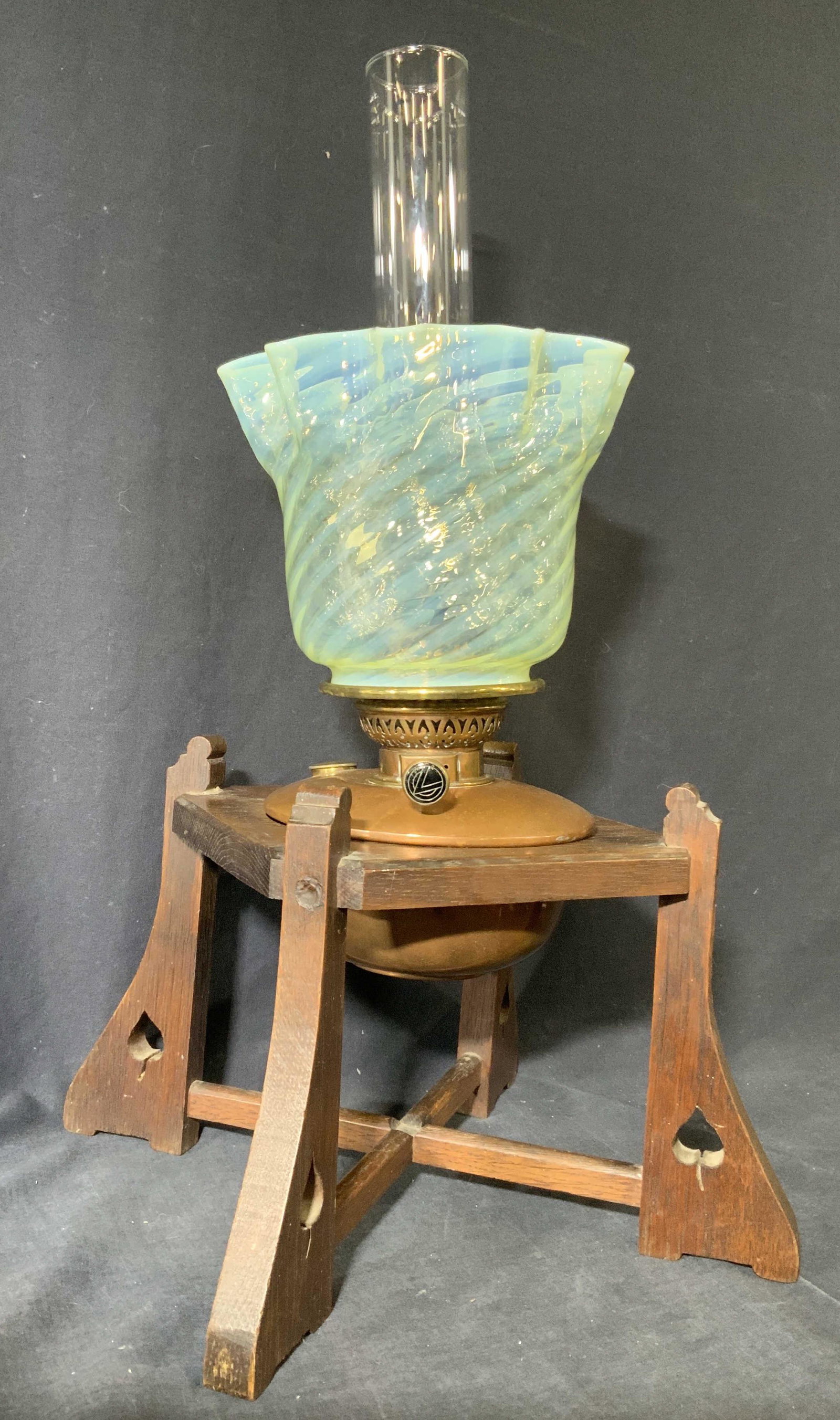 Antique English Arts&Craft Oil Lamp Vaseline Shade: Antique 1890â€™s English arts and crafts oil lamp with Vaseline shade. Lamp has carved wooden base with 4 legs. Piece has x shaped stretcher between legs. Lamp has vaseline shade. Piece has knob 