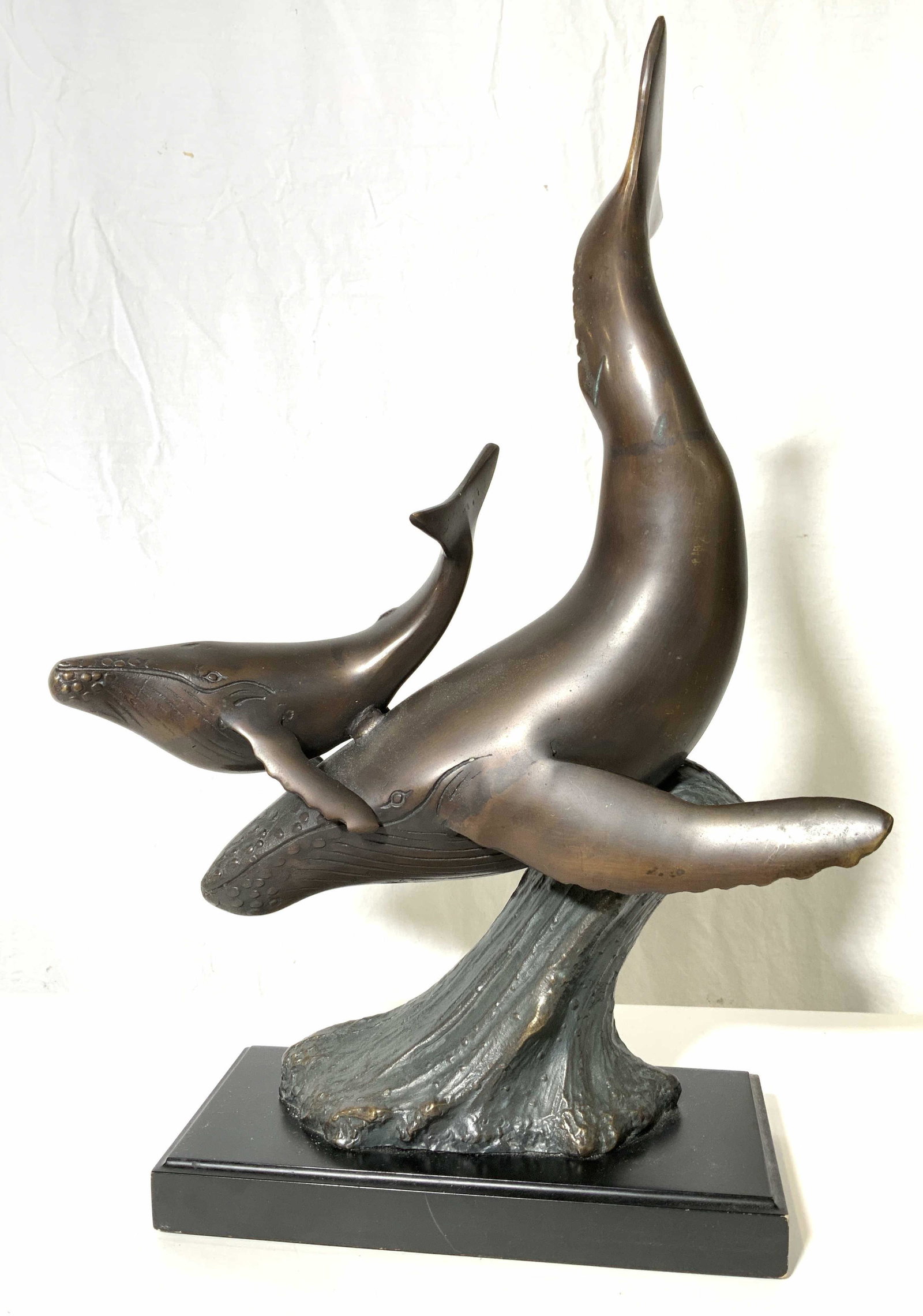 Brass Grey Whale & Calf Sculpture: Cast brass whale sculpture. Depicts a Gray Whale mother and calf riding a wave. Crafted from brass, bronze finished, finish has lifted in some areas. No apparent signatures or markings. Base appears t