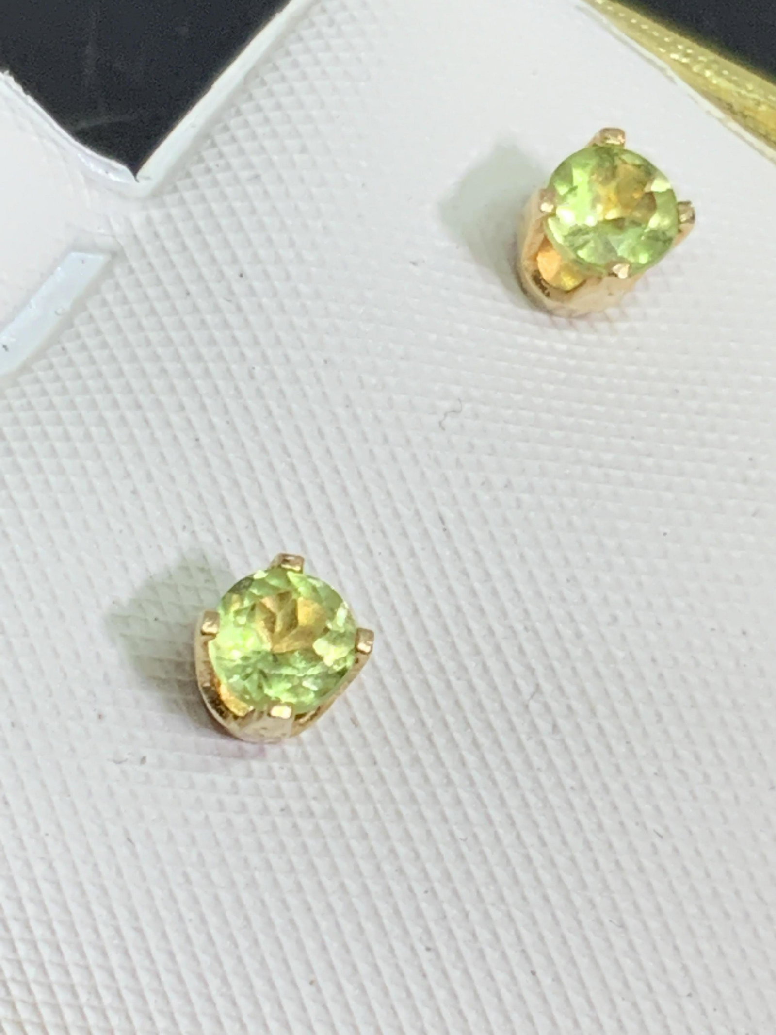 14K Gold Light Green Natural Stone Stud Earrings: A set of 14 karat gold earrings with faceted solitary light green natural gem stones in a prong setting. Earrings are marked 14k on the reverse of butterfly backings and on earring posts. Cushion read