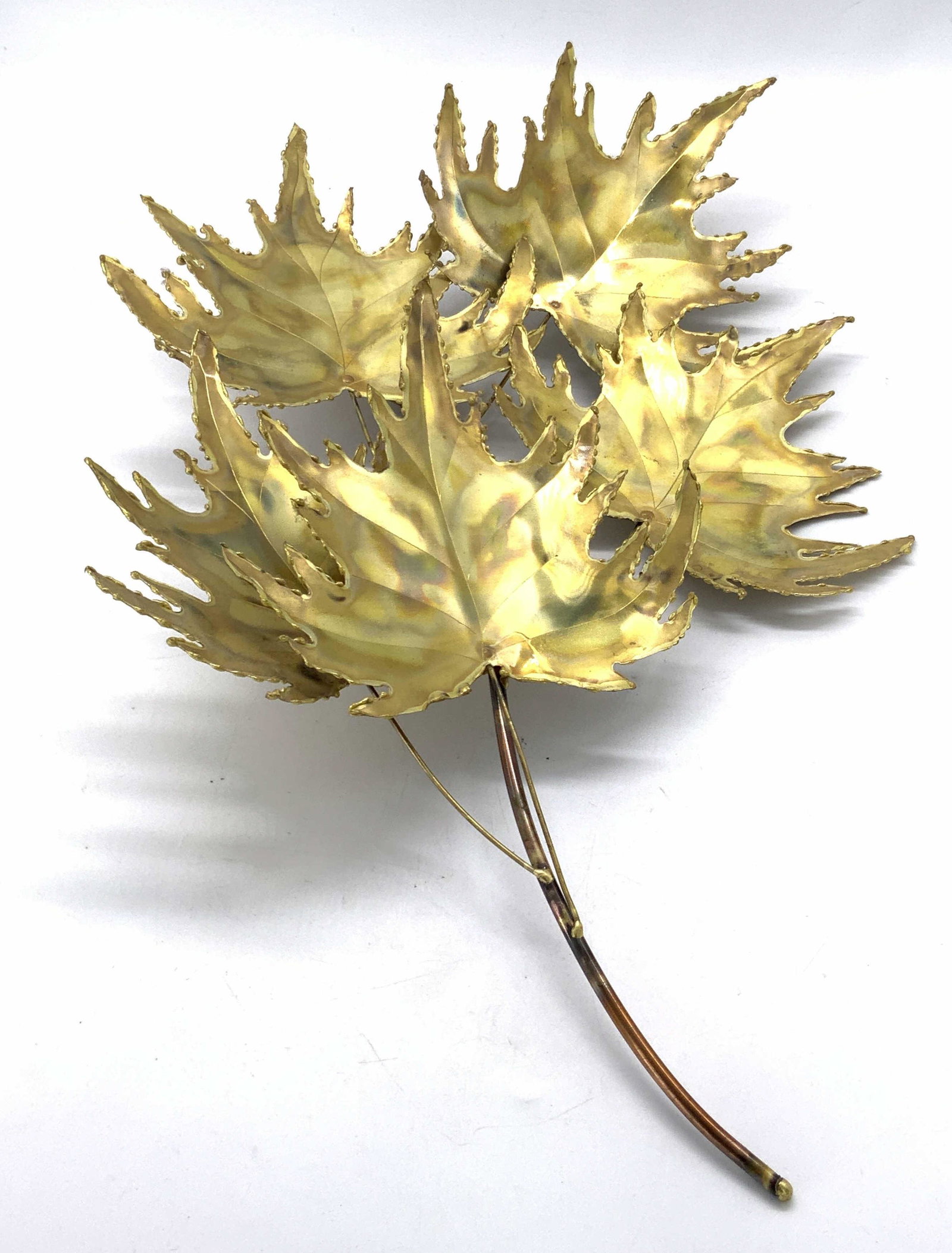 Vintage Gold Tone Leaf Bushel Metal Sculpture: A vintage gold tone metal leaf bushel sculpture. Leaves are affixed to a metal branch. Piece appears to be handmade. Piece has some surface wear consistent with exposure and age. Measures approx 16L x