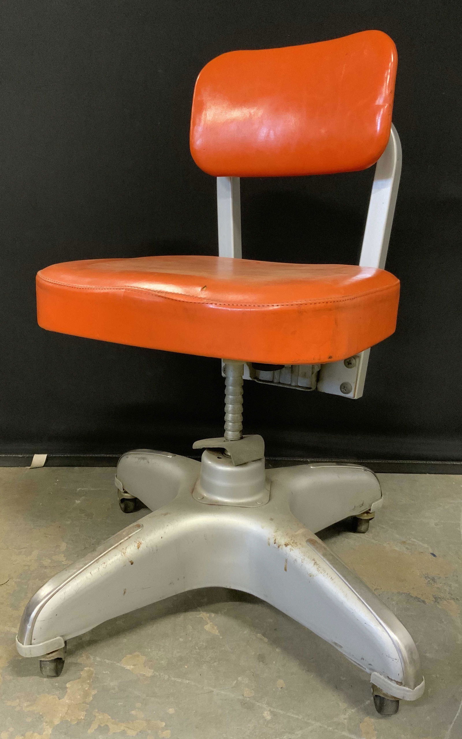 Vintage Industrial COLE-STEEL Swivel Chair: Vintage swivel chair, MCM style. Back of chair reads as COLE STEEL. Industrial style chair, rests on four wheels. Orange upholstery. Wear is consistent with age and use. Measures approx 31 inches h, 1