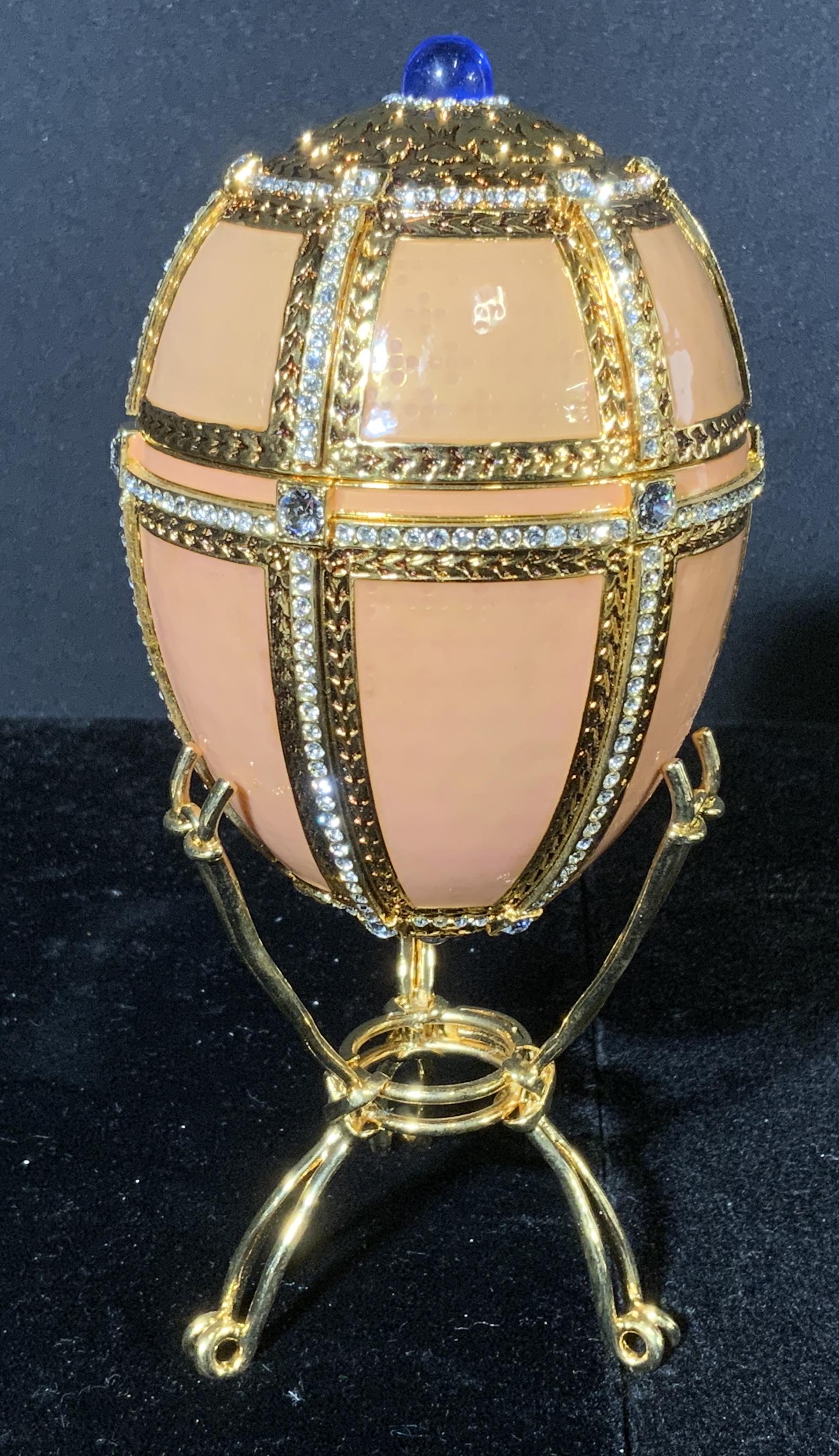MMA FABERGÃ‰ Egg Trinket Box w Stand: Ornate FABERGÃ‰ egg. Peach toned, bejeweled, gold toned lattice, top and bottom capped with gold detailing. Includes a interior is lined with fabric. Wear is consistent with age and use. Interior r