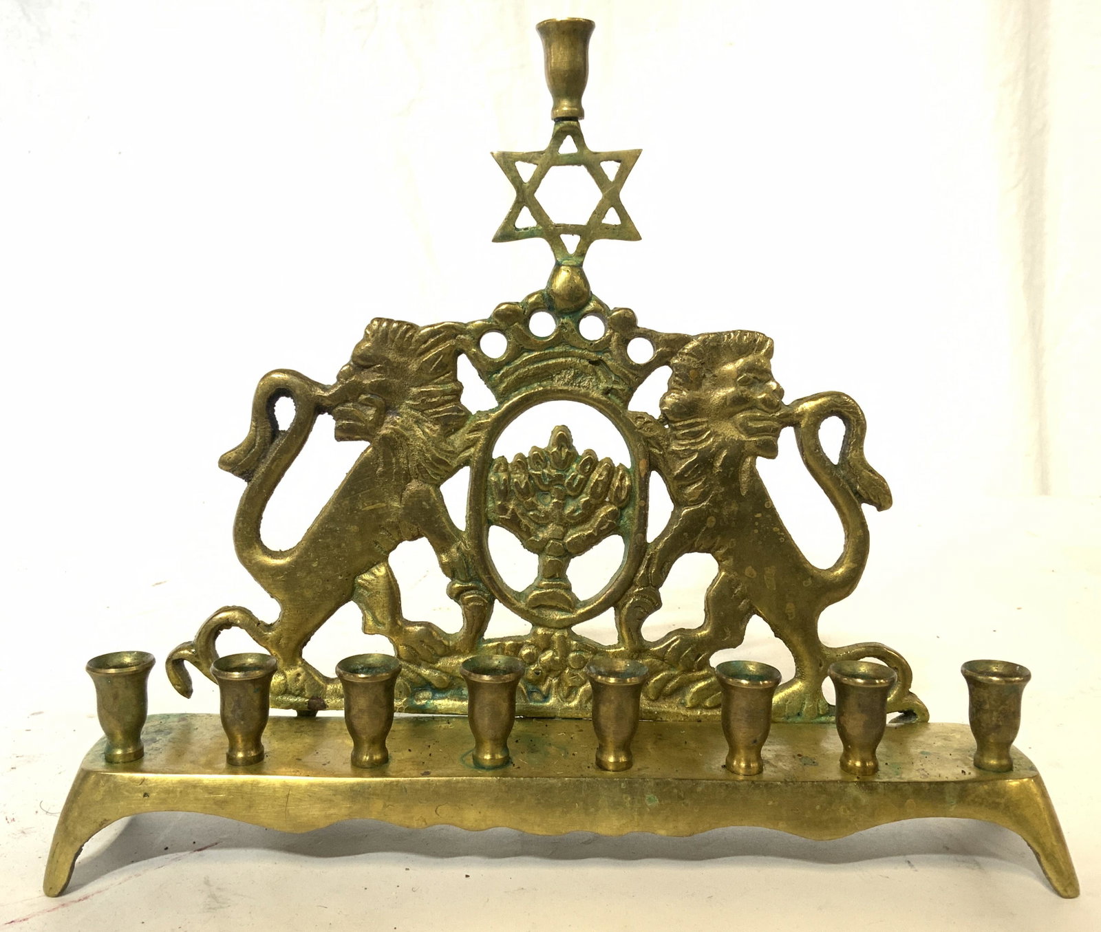 Vintage Brass Judaica Menorah W Lions: Menorah is gold toned & brass. Piece is vintage possibly antique. Menorah has Star of David & Lion structures on each side. Menorah measures approx 7.5 inches tall 8.5 inches wide. Menorah, judaica, j