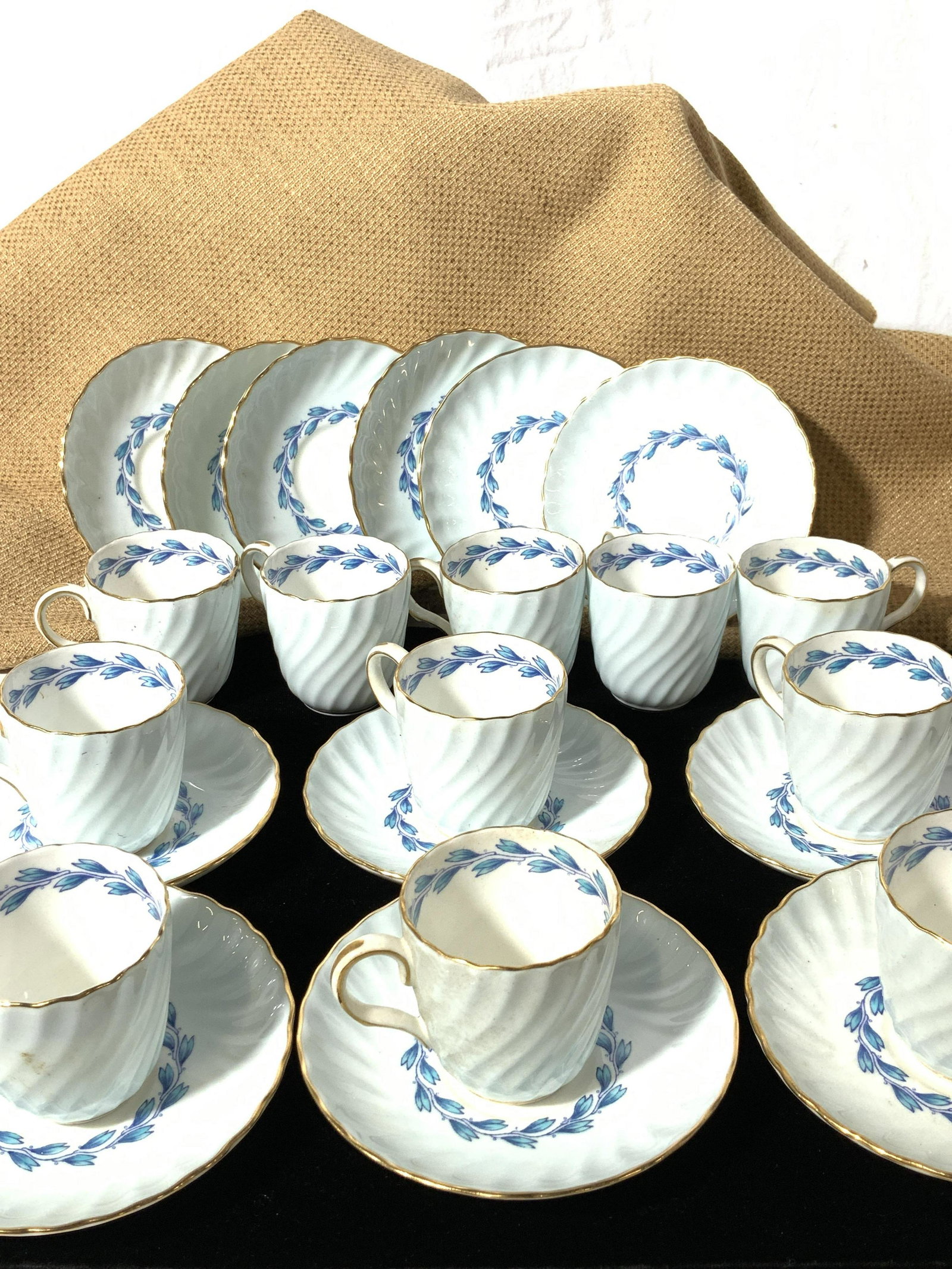 MINTON Fine Bone China Demitasse Set, 23: Hallmarked Minton of England, White ware with light blue exterior paint, hand painted Blue Laurel and gilt rim. Reads Minton China Cheviot 13-52 or 12-52 on some saucer pieces, other pieces with hand 