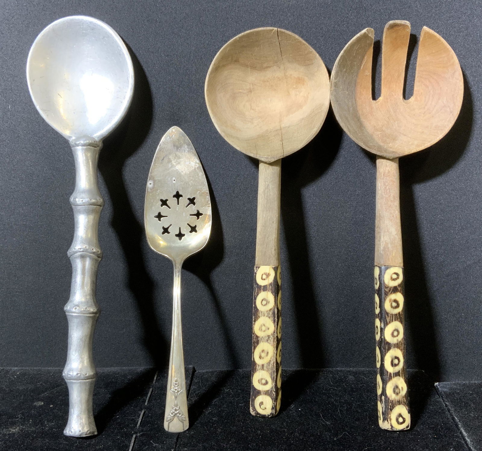 Lot 4 vintage Serving Utensils: Includes 2 spoons, 1 fork, and a cake knife. Cake knife marked GAILSTYN SILVER PLATE. Two utensil handles appear to be bone or shell. Wear is consistent with age and use. Largest piece measures approx