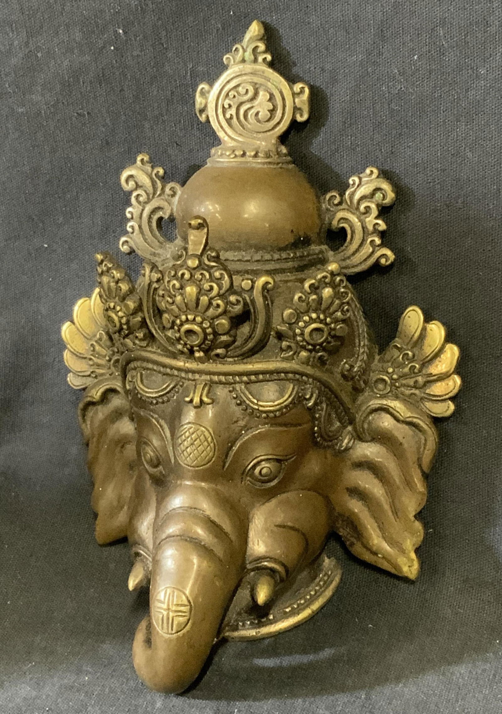 Cast Bronze of Head of Ganesha: Cast Bronze of Head of Ganesha, measures 4 l x 2 1/8 w x 5 1/2 h inches, wear consistent age and use. Artwork, wall art, home decor, Ganesha, Ganesha art, Hindu, Hindi art,Hindu sculpture, cast Hindi