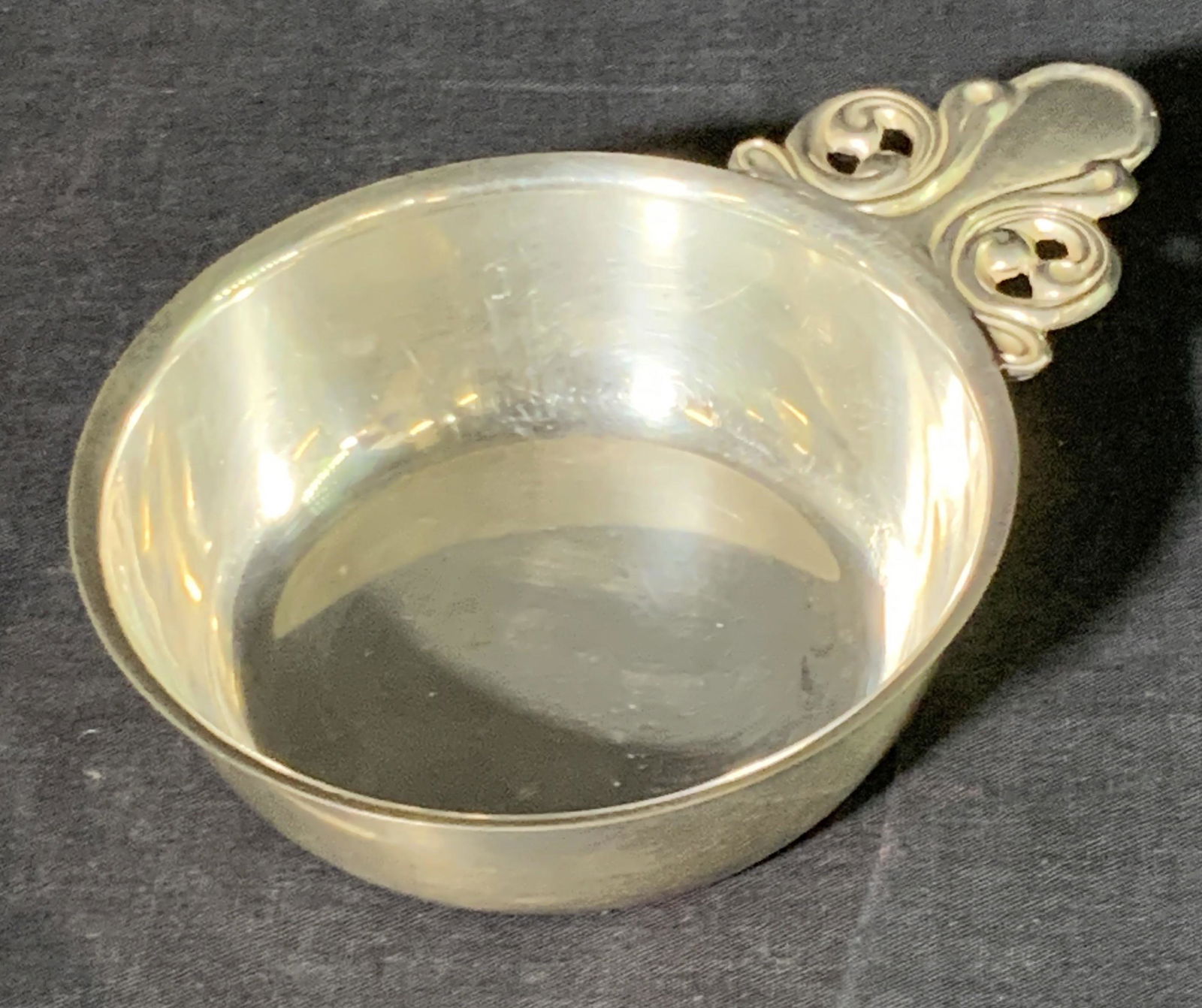 Vintage Silver Tone Metal Porringer: A vintage silver tone metal porringer. Scrollwork handle to the side. Some surface scratches and wear consistent with use and age. Measures approx 1.5H x 6W in. Measured at widest point. Vintage Colle
