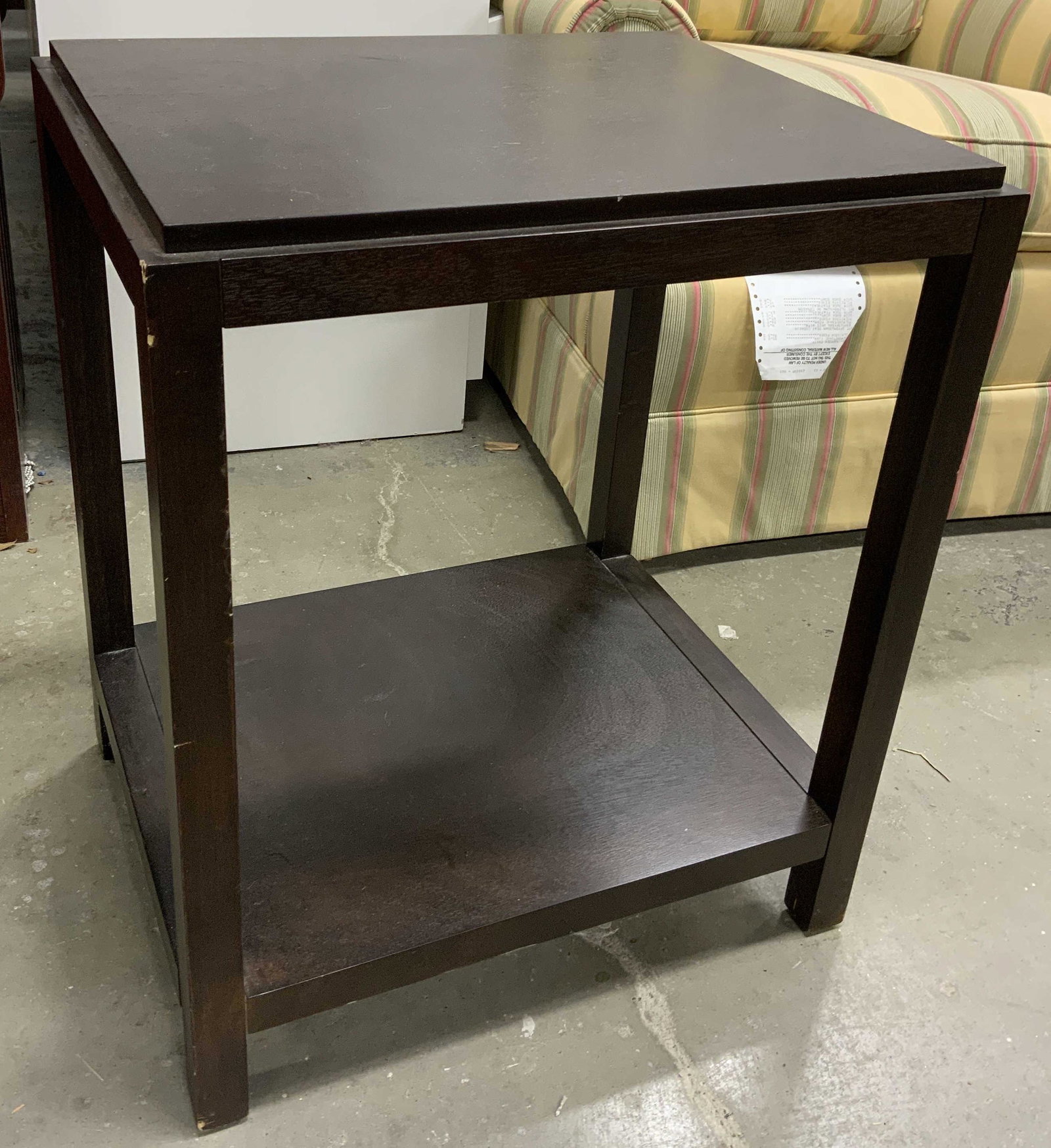 Wooden Espresso Toned Side Table: Side table is espresso toned and wooden. Piece has 4 legs with board stretcher in between. Table measures approx 23 inches tall 19 inches deep 15.25 inches wide. Side table, end table, wooden table, v