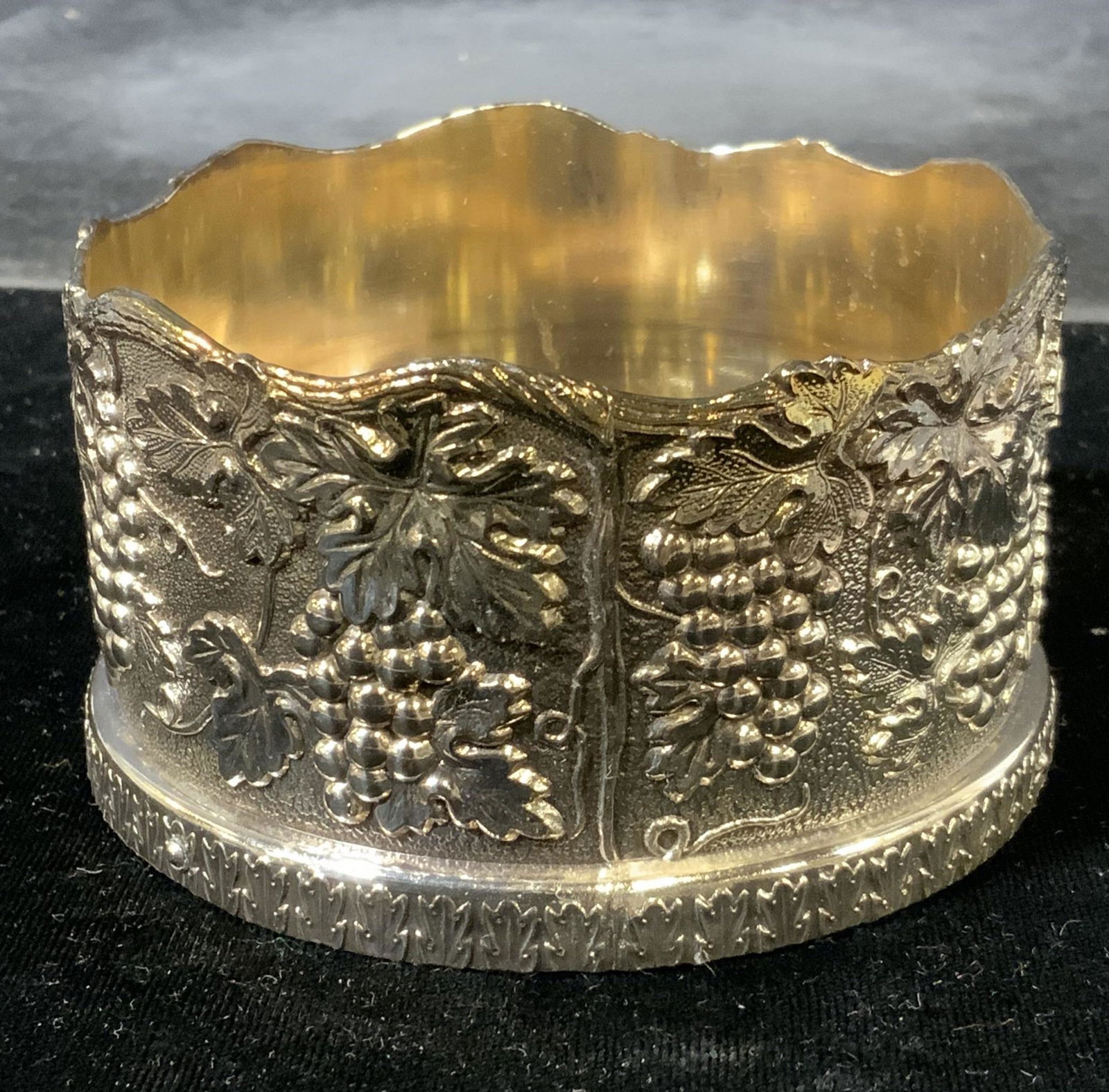 Cast Metal & Wood Wine Bottle Holder, Japan: Cast metal wine bottle coaster. Decorated with cast grape and vine like detailing. Underside is lined with fabric, reads as MADE IN JAPAN. wooden interior. Wear is consistent with age and use. Measure