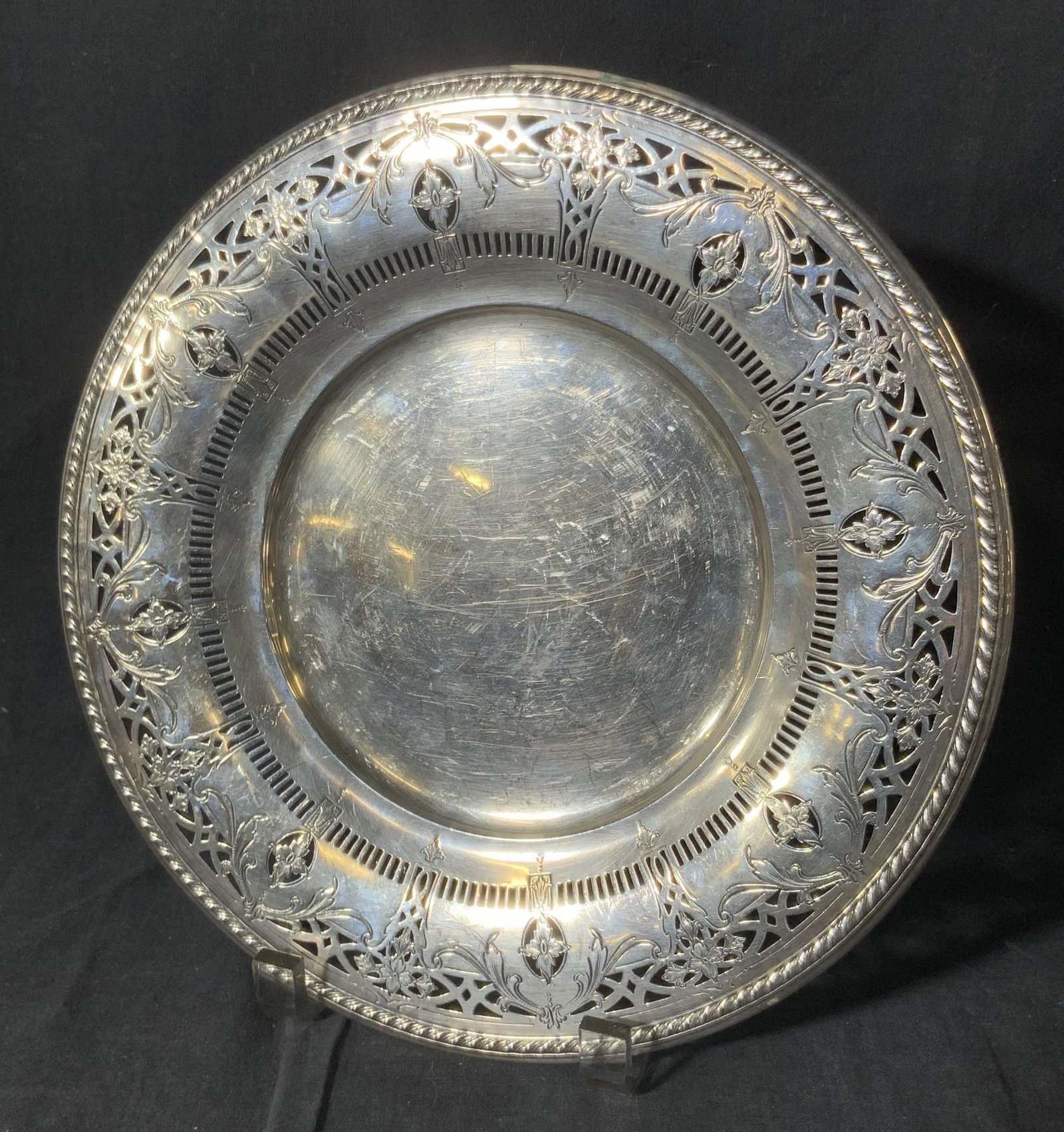 WM ROGERS Sig Vintage Pierced Silver Plated Plate: A vintage silver plated plate decorated with piece red and etched metalwork designs. Underside signed WM ROGERS. Piece has some surface scratches and wear consistent with age and use. Measures approx.