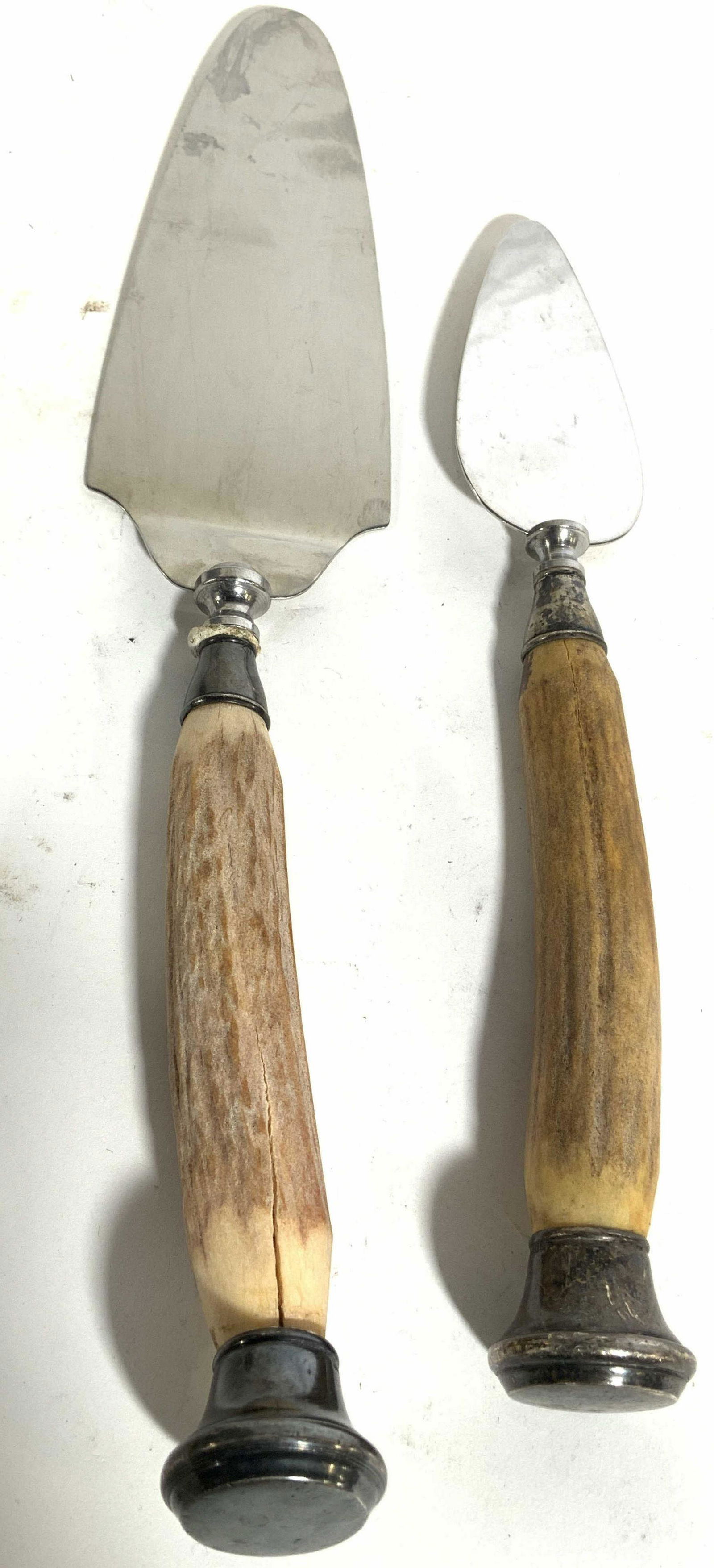Lot 2 Sterling Silver Cake Knives W Bone Handles: Lot includes 2 cake knives. Each handle appears to possibly be carved bone. Blades of each knife are stainless steel. Lowest edges of handles are Sterling Silver. Areas directly under blades are also