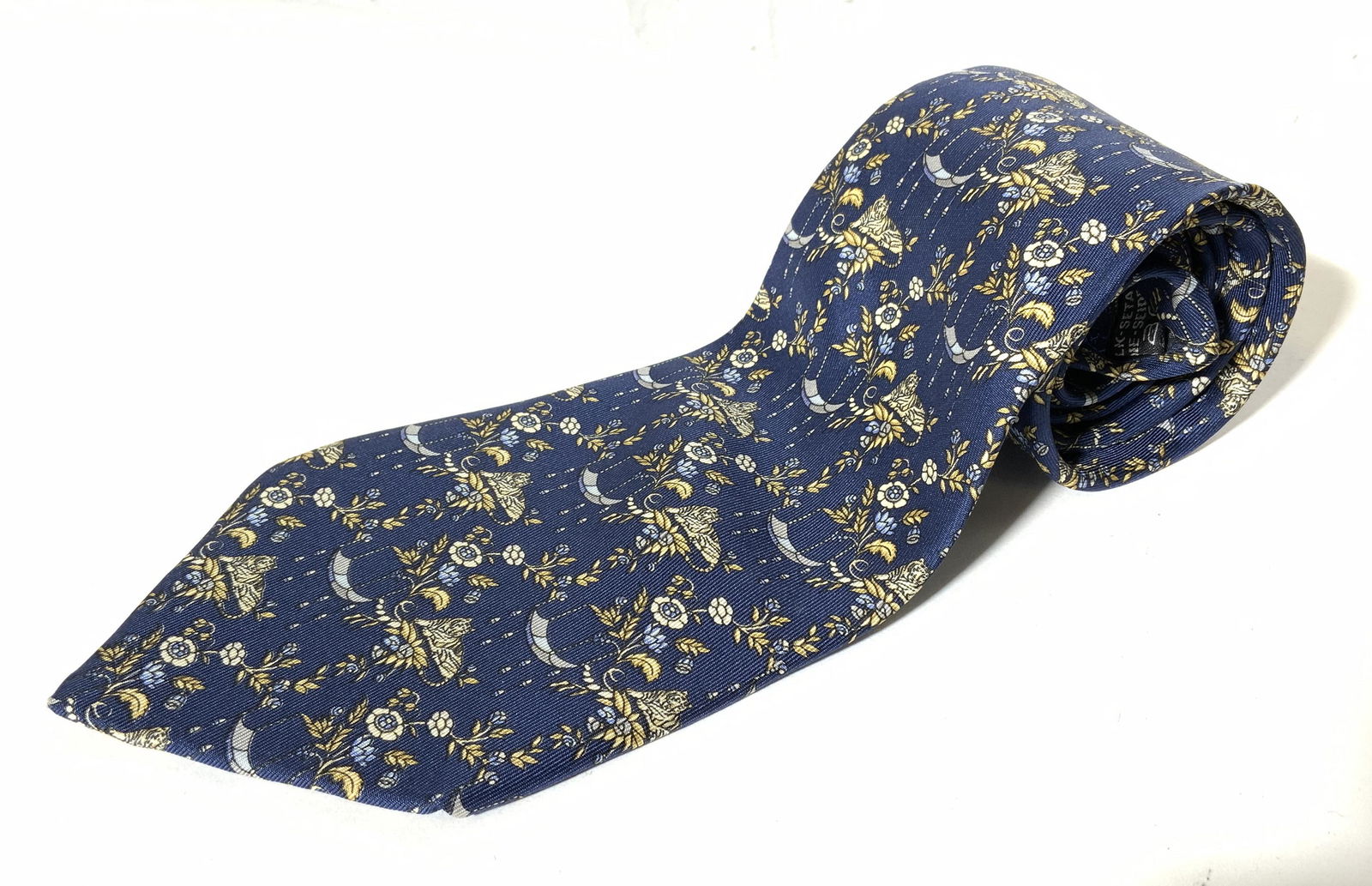SALAVATORE FERRAGAMO Silk Men’s Necktie: Silk necktie by SALVATORE FERRAGAMO. Royal blue base, decorated with scrolling gold plant & tiger patterns. Label reads as SALVATORE FERRAGAMO MADE IN ITALY. Wear is consistent with age. Measures appr