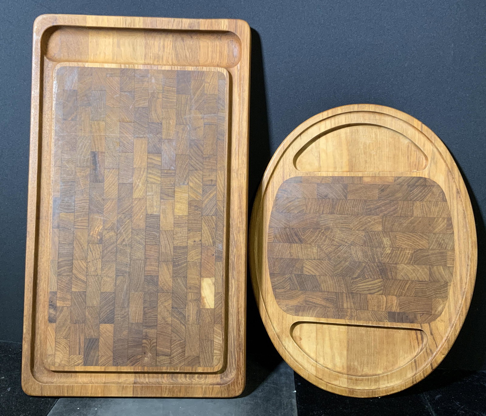 Lot 2 Hardwood Carving Boards: Lot 2 hardwood carving boards. Undersides stamped as DANSK INTERNATIOMA. DESIGNS LTD IHG/DENMARK, and NISSEN. Wear is consistent with use. Largest piece measures approx 22.75 inches long, and 13 inche