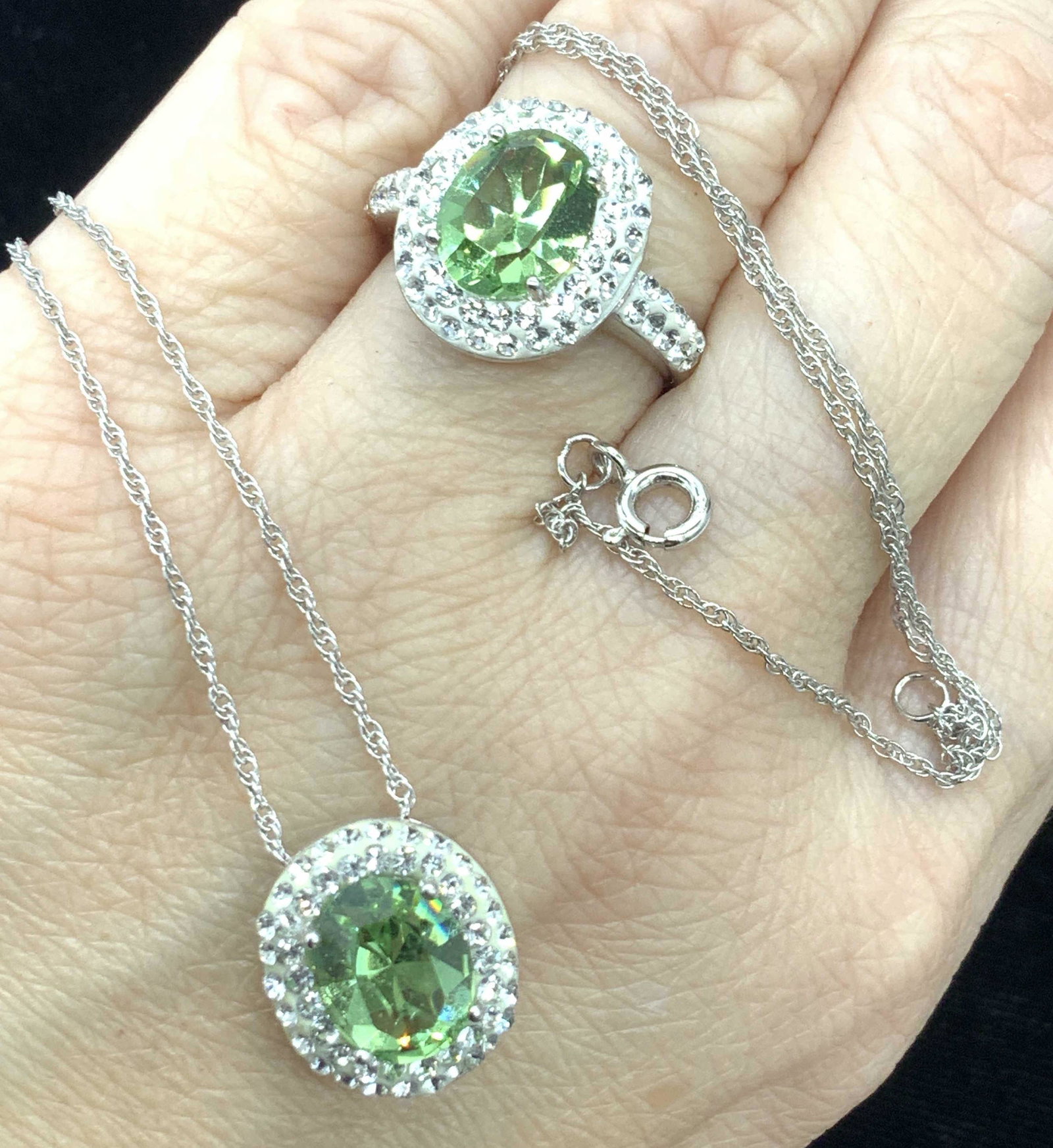 AU Sterling Crystal Ring & Necklace Set: Matching Pendant Necklace and Ring with solitaire Crystal ‘prasiolite toned/ peridot toned’ surrounded by clear crystal halo. Both pieces marked AU 925 with copyright symbol. Ring 6.75-7. Necklace