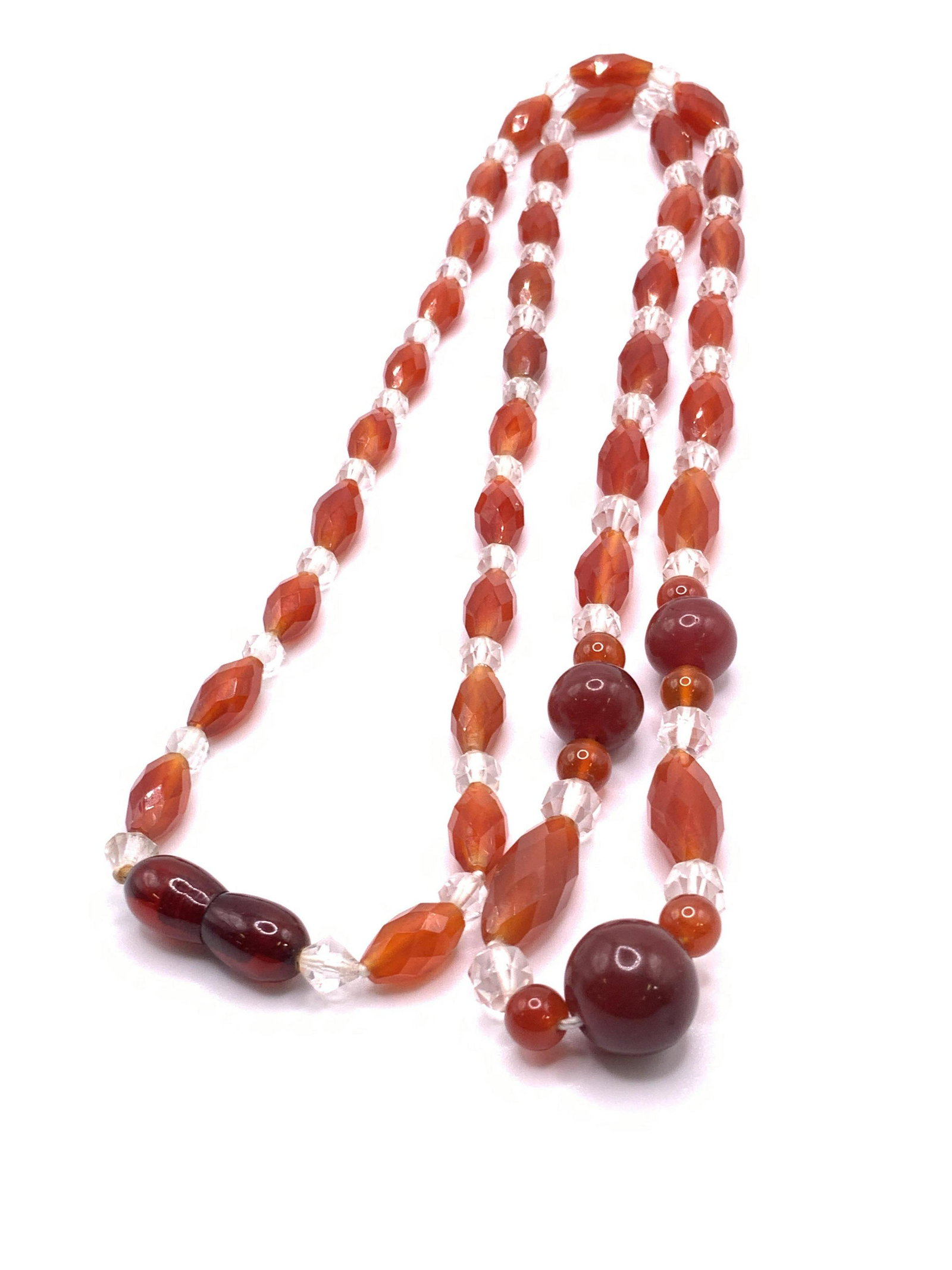 Vintage Carnelian Tone Glass Beaded Necklace: A necklace comprised of faceted beads that are clear & carnelian hues. Spheres and navette forms. Necklace secures with a screw clasp. Necklace length approx 33 in. Some surface wear consistent with u