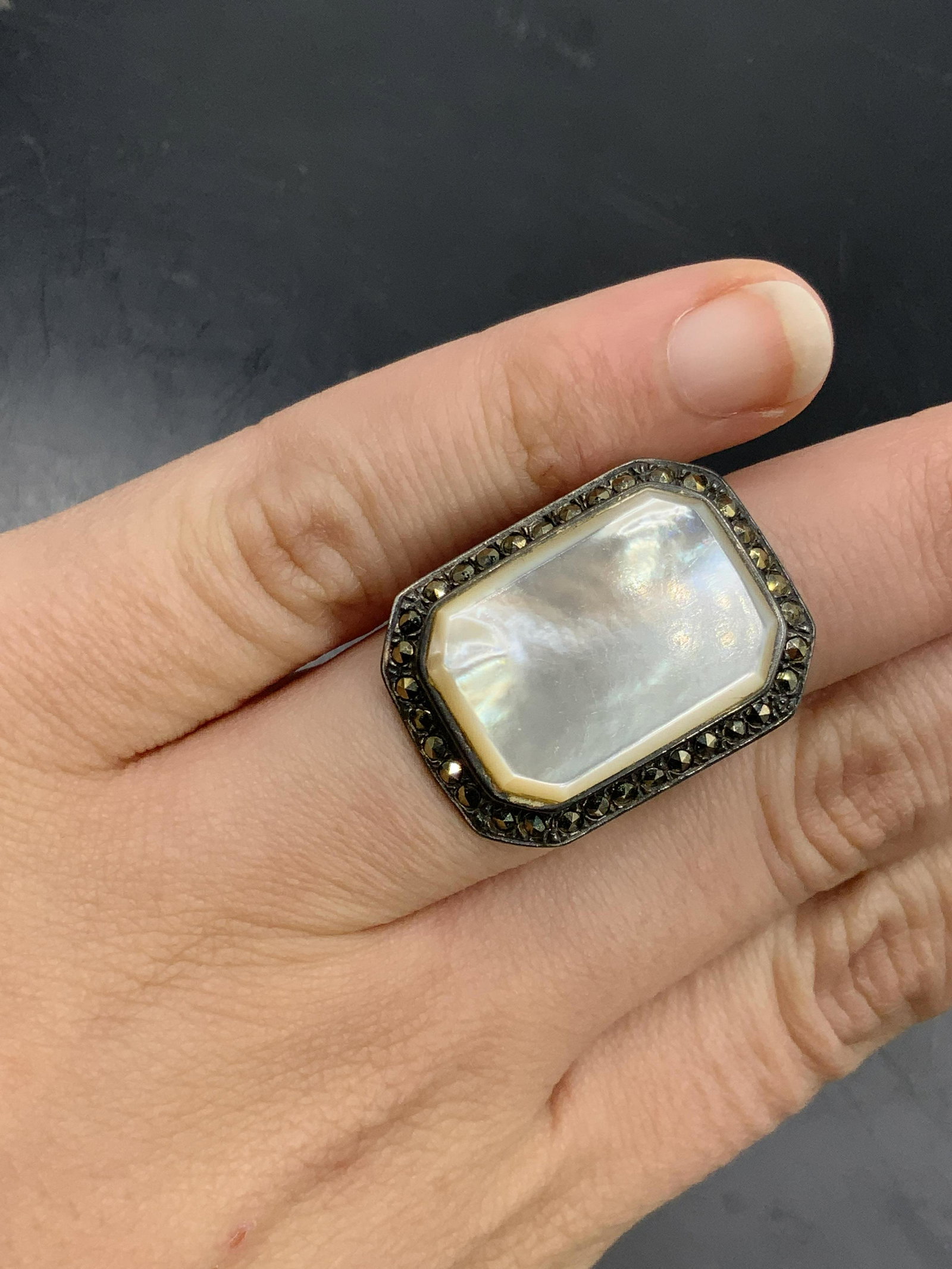 Vintage STERLING Mother of Pearl Marcasite Ring: A vintage sterling silver ring with a rectangular polished mother of pearl focal point surround by marcasite. Interior band marked 925. Approx. Size 5. Total weight .37 ozt. Wear to piece consistent w