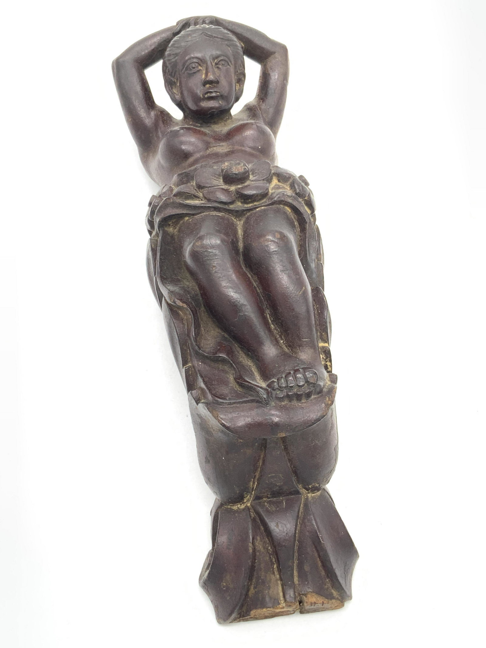 Hand Carved Partial Female Nude Figural, Wall Art: A hand carved and etched figural depicting a partially nude woman. She has both hands folded behind her head. Florals accent her waist. Crafted from a rich brown hued wood. Reverse has holes for displ