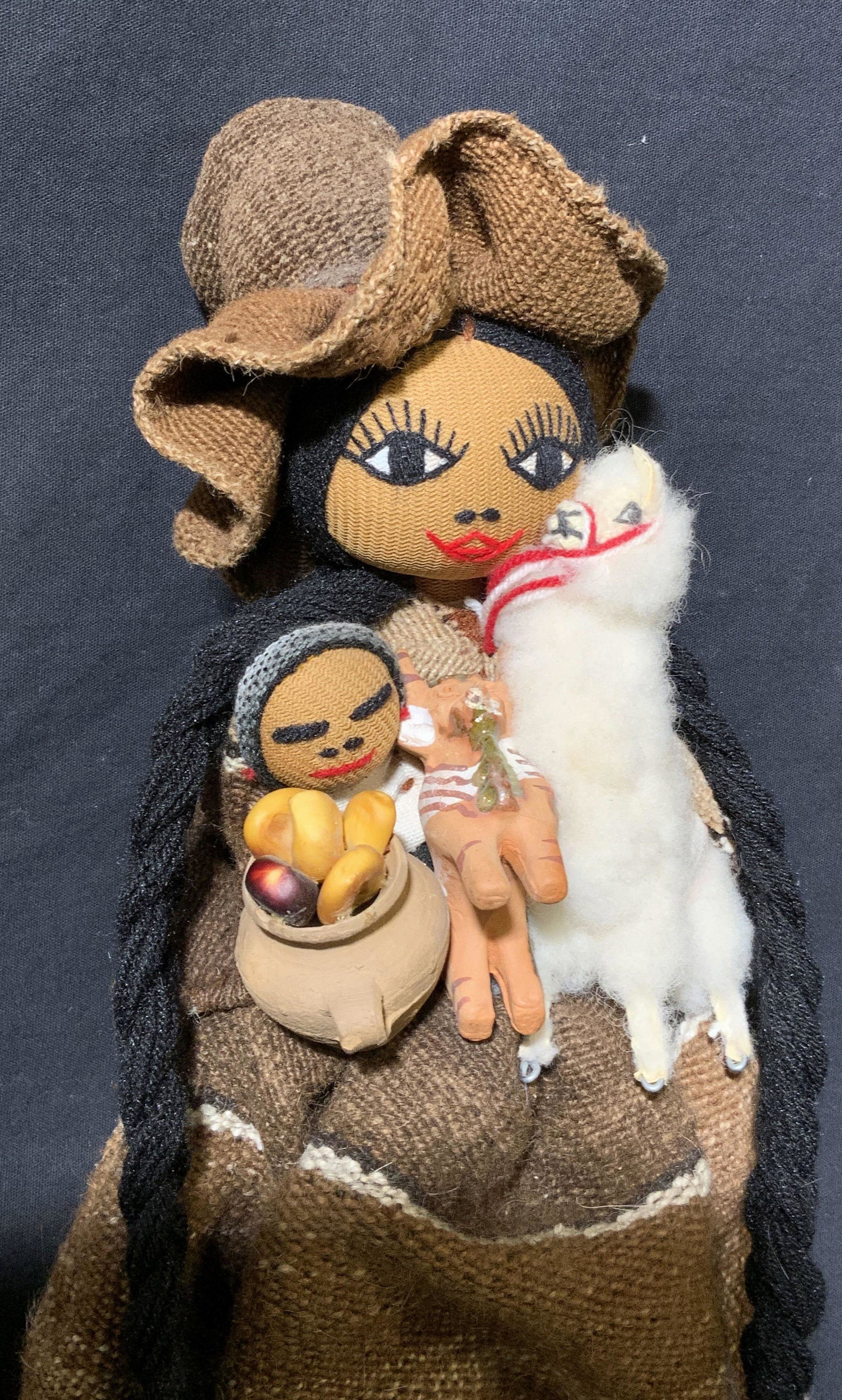 Handmade Andean Woman Doll: Handmade Andean Woman Doll, shows mother with a baby on her shoulder and another on her chest while carrying a llama and a fruit vessel, measures 6 1/2 w x 14 1/2 h inches, wear consistent with age an