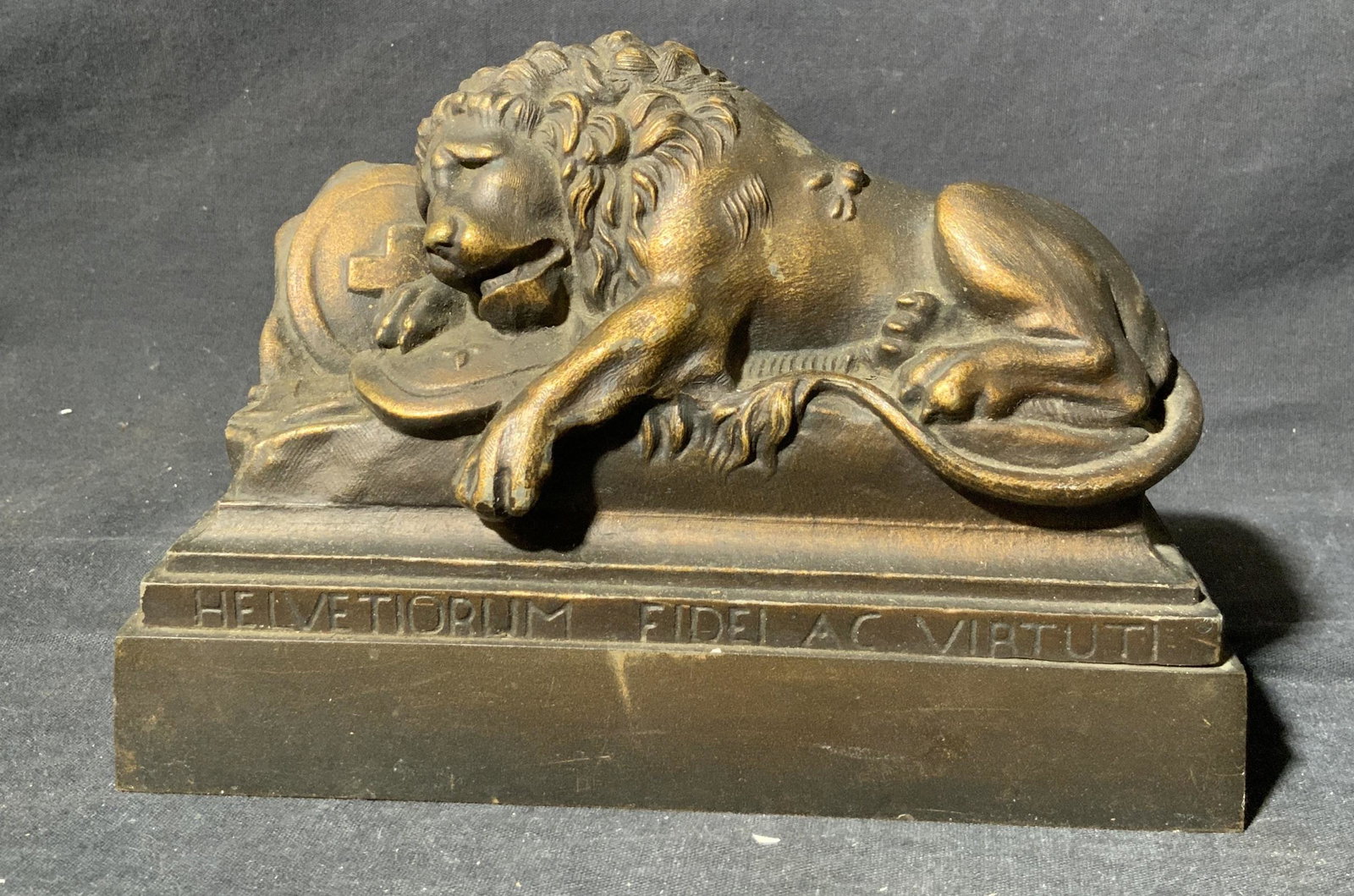 Casted Bronze Sculpture of a Lion on a Tombstone: Casted Bronze Sculpture of a Lion on a Tombstone, Inscriptions read ‘Helvetiorum Fidel AC Viatuti’, measures 7 1/4 l x 3 w x 5 1/4 h inches, wear consistent with age and use. Art, artwork, tableto