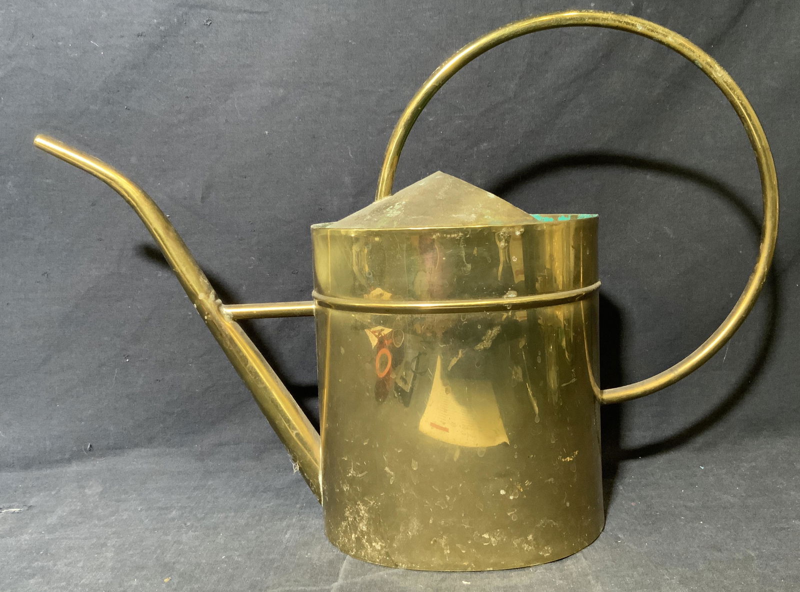 Brass Toned Watering Can: Brass Toned Watering Can, no apparent inscriptions or mark to piece, subject a watering can with a brass toned exterior and a green toned interior, measures 12 1/2 x 18 x 5 1/2 inches, surface wear to