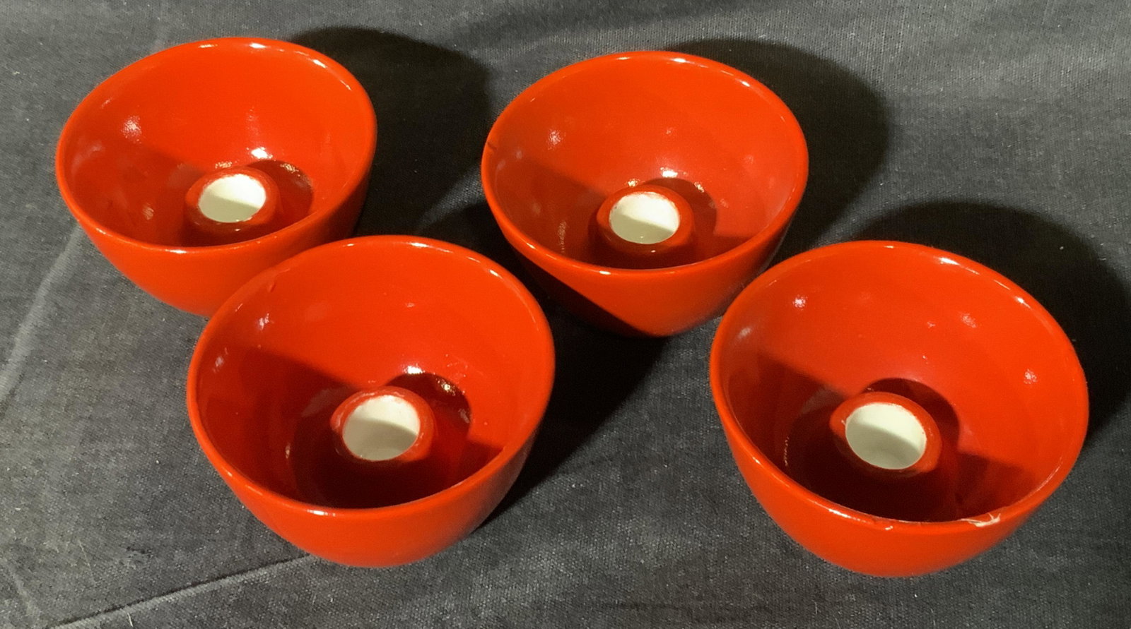Lot 4 ARABIA Finland Candleholder Bowls: Lot 4 ARABIA Finland Candleholder Bowls, underside reads ‘ARABIA MADE IN FINLAND’, subject four small red bowl candleholders, measures 1 1/2 x 2 1/2 x 2 1/2 inches, surface wear to pieces. abletop