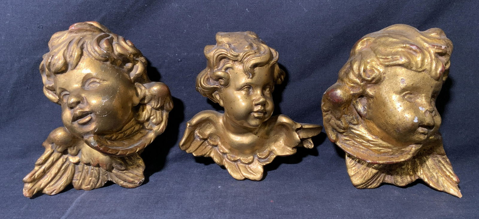 Lot 3 Putti Head Decorative Accessories: Lot 3 Putti Heads, no apparent inscriptions or mark to piece, subject two wooden one composite all with gold leaf putti heads, measures between 6 and 7 inches tall, surface wear and chips to pieces. A