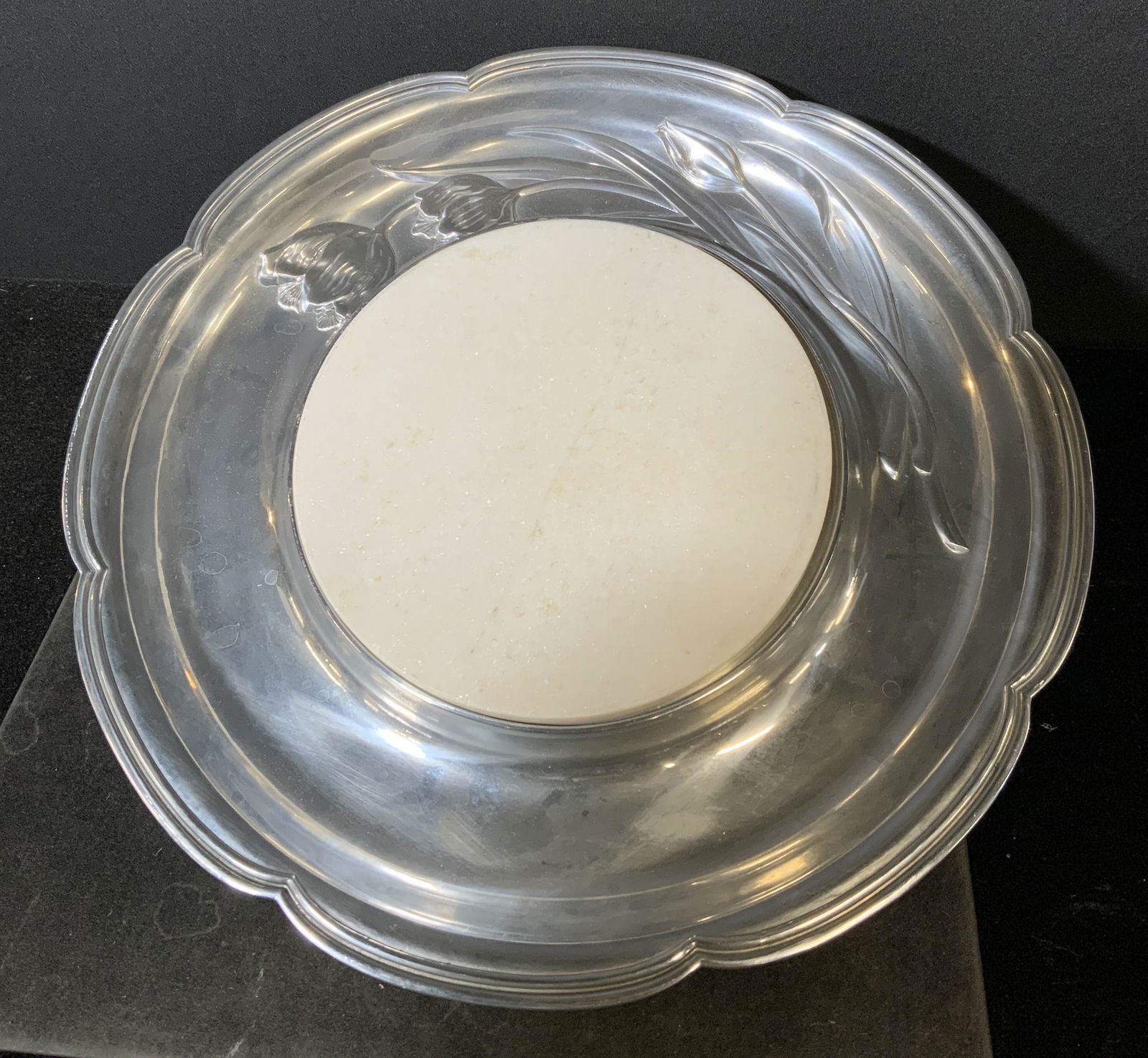 WILLIAMSBURG REED & BARTON Cheese Board: Metal tray, with cut granite insert. Underside reads as WILLIAMSBURG REED & BARTON. Decorated with cast tulip formed detailing. Wear is consistent with age and use. Measures approx 15 inches in diamet