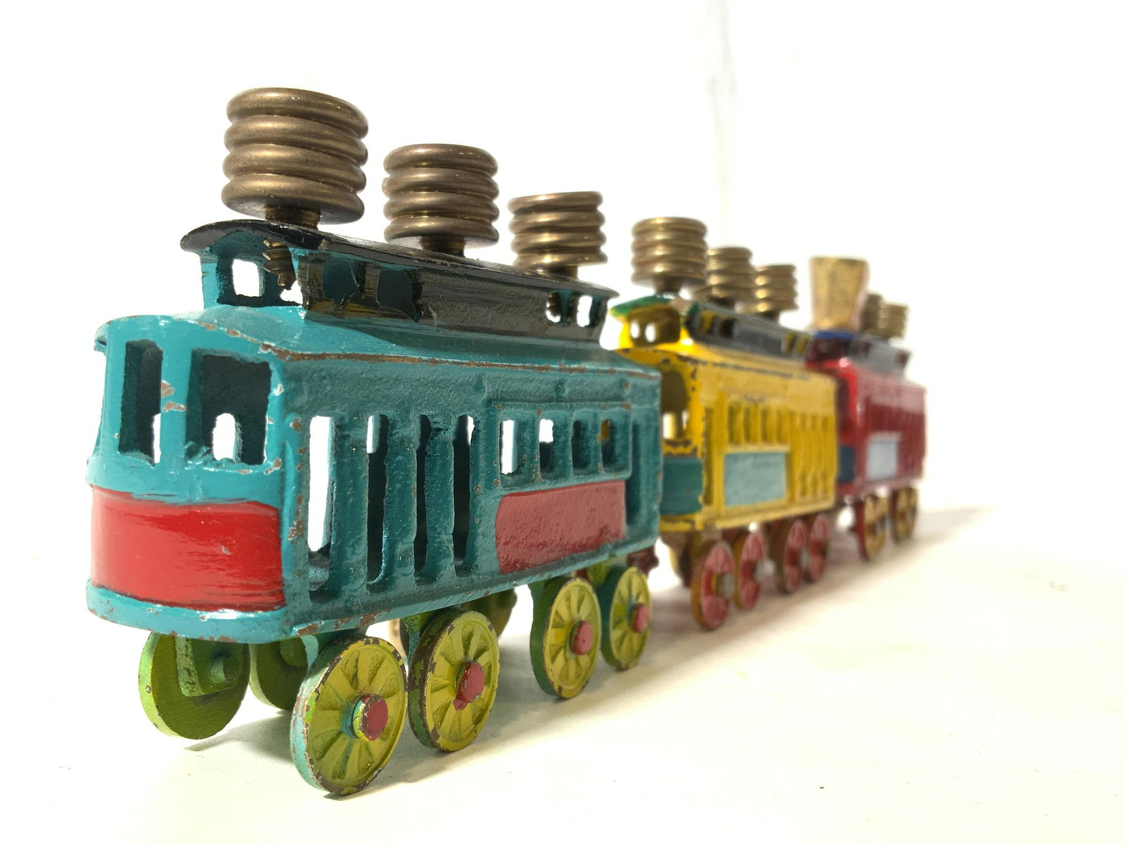 Vintage Metal Train Judaica Menorah: Menorah is vintage & metal. Pieces appear to possibly be hand painted. Each train car has 3 gold toned candle holders. Each piece measures approx 3 inches long 2.25 inches tall. Menorah, metal train m