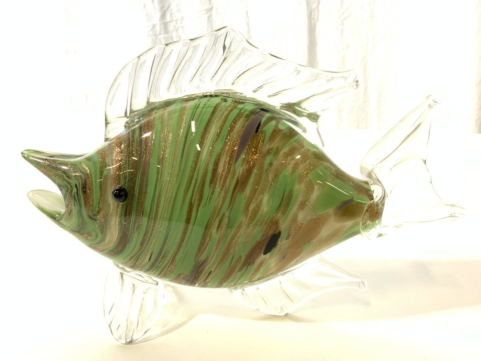 HQT Handmade Art Glass Fish W Gold Fleck: Fish sculpture has tag which reads HQT HANDMADE HOME DESIGN. Piece is glass with areas which appears to be hand crafted, hand blown. Interior has gold fleck, green, white & purple toned detail . Piece