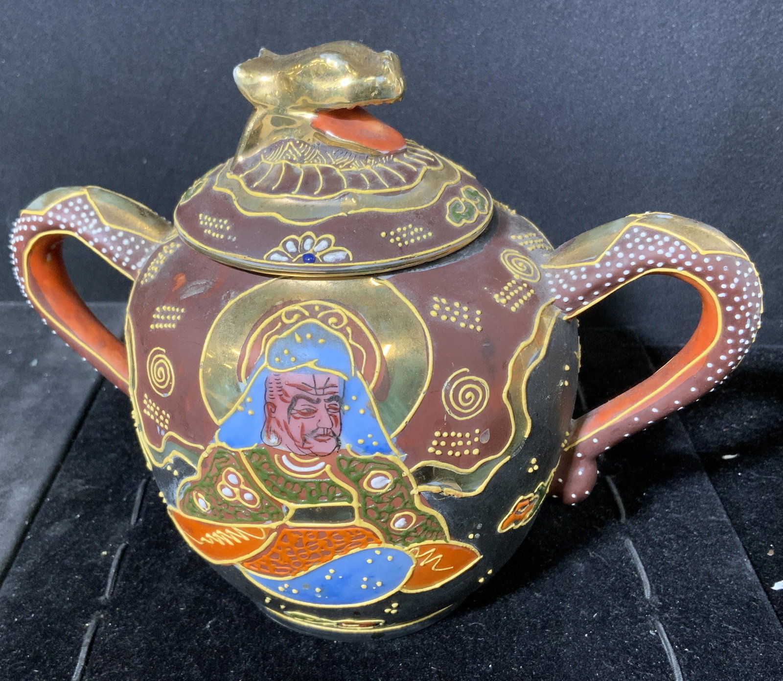 Hand Painted Satusma Style Jar, Japan: Handled jar. Hand paimted, depicts a robed male and female figure, finial on lid resembles the head of a grain. Underside is stamped, reads as HAND PAINTED, JAPAN. Measures approx 5.5 inches h and 7 i