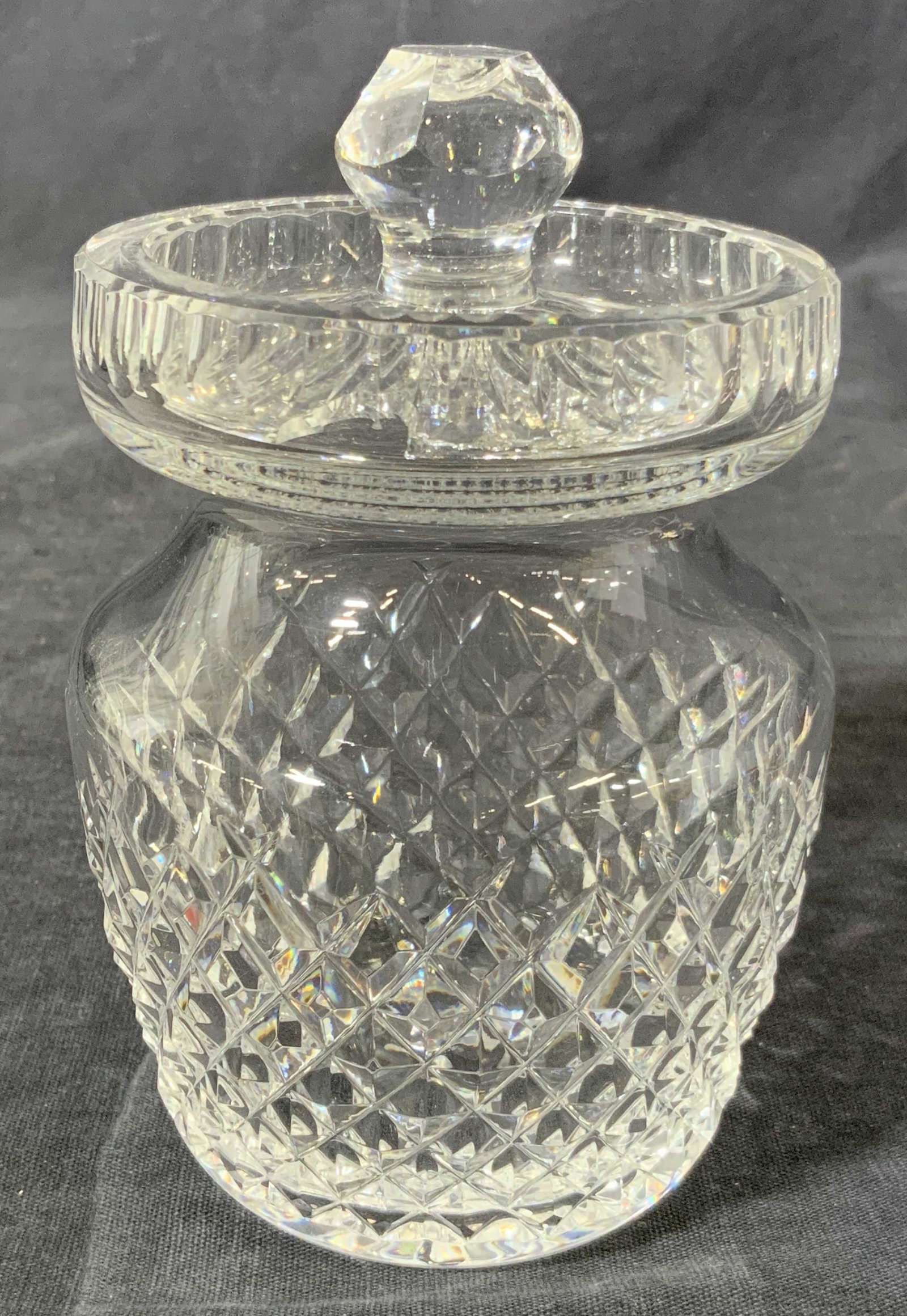 WATERFORD Vintage Cut Crystal Sugar Jar: A small vintage jar made of cut crystal, hallmark ‘Waterford’ on underside. Has a faceted diamond cut to exterior, lid has multi faceted topper and floral motif. Approximately 5. 25 in tall and 3 