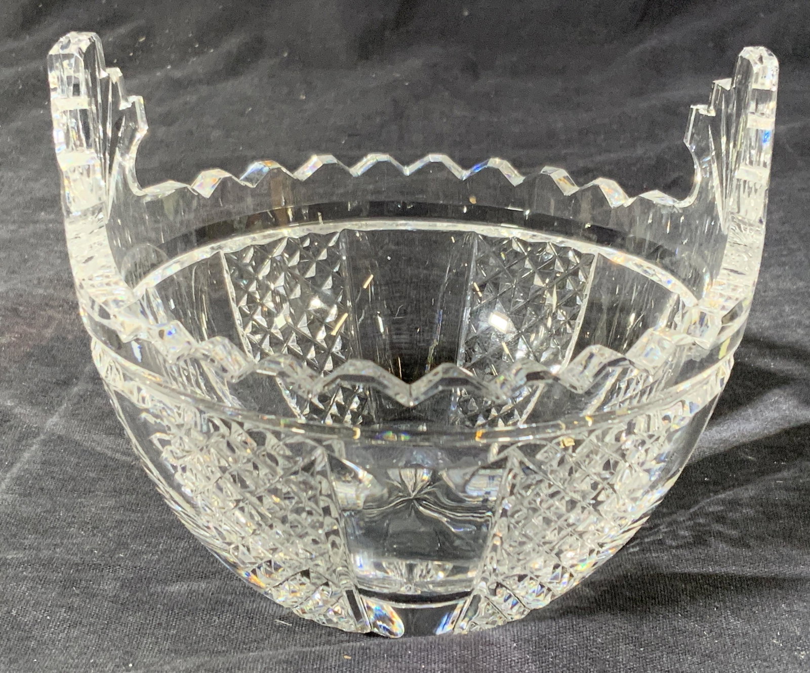 WATERFORD Cut Crystal Bowl: A small bowl Hallmark â€˜Waterfordâ€™ on underside, with a saw toothed rim and checkered sections cut into the exterior. approximately 4 in tall and 4.75 in wide. Some scratching and wear to 
