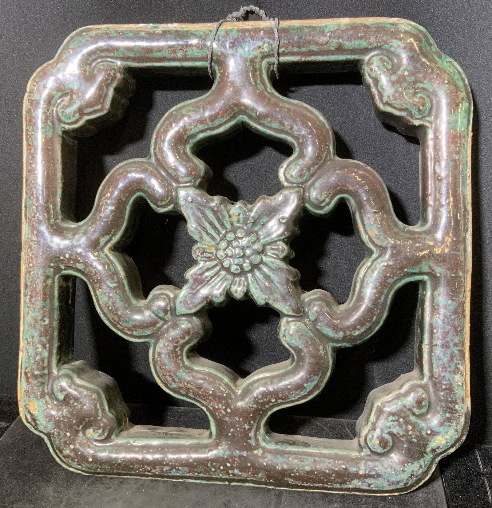 Vintage Asian Breezeway Stoneware Tile: Vintage, possibly antique. Center floral motif surrounded by supports connecting to a square form border that has semi rounded borders. Distressed, celadon tone, tile is glazed. Wear is consistent wit