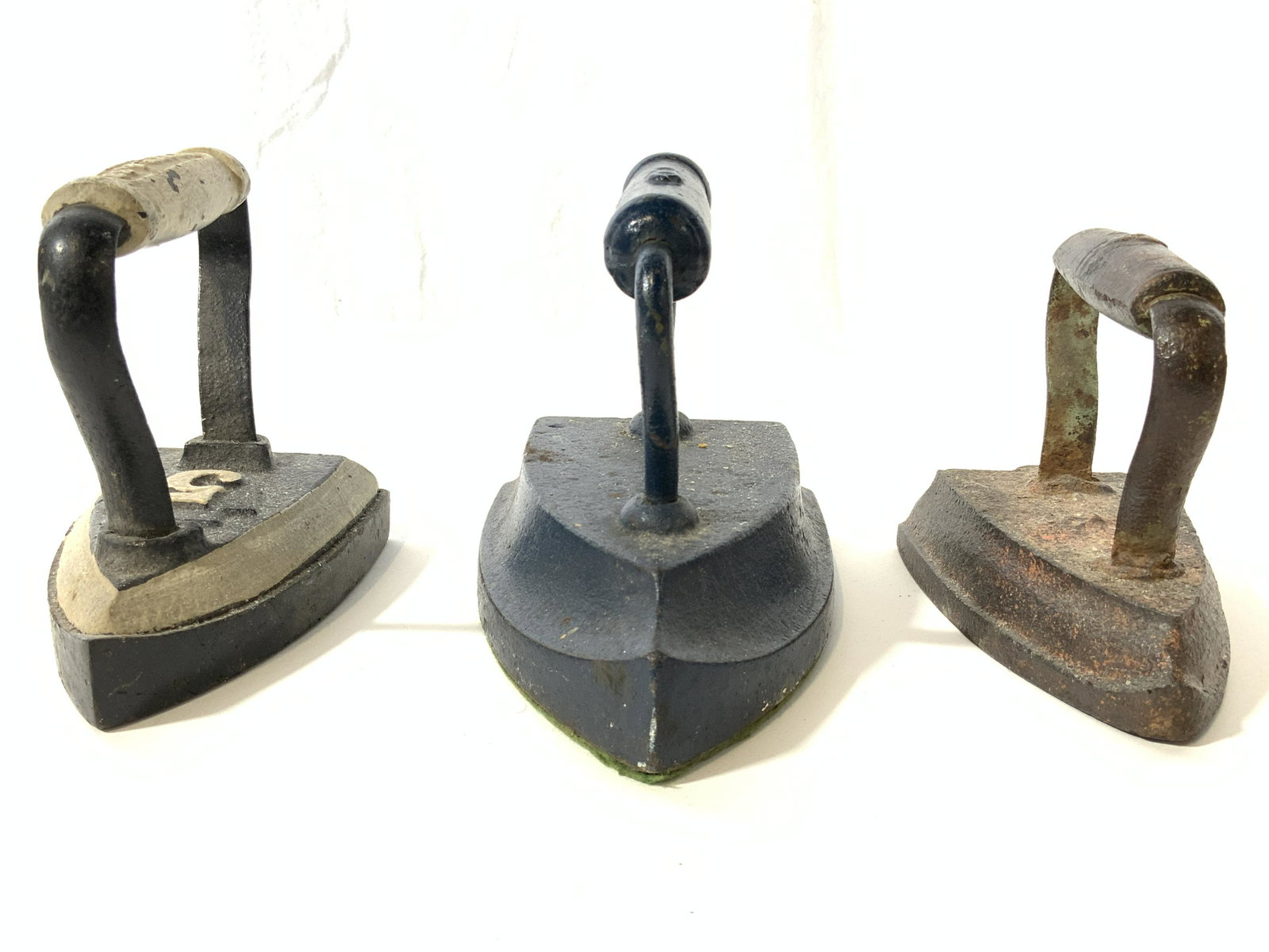 Lot 3 Painted Antique Assorted Irons: Irons are antique. Each piece appears to be hand painted. Lot includes 1 blue 1 black & slate & 1 bronze toned iron. Largest piece measures approx 7 inches long 5 inches tall 4 inches wide. Iron, asso