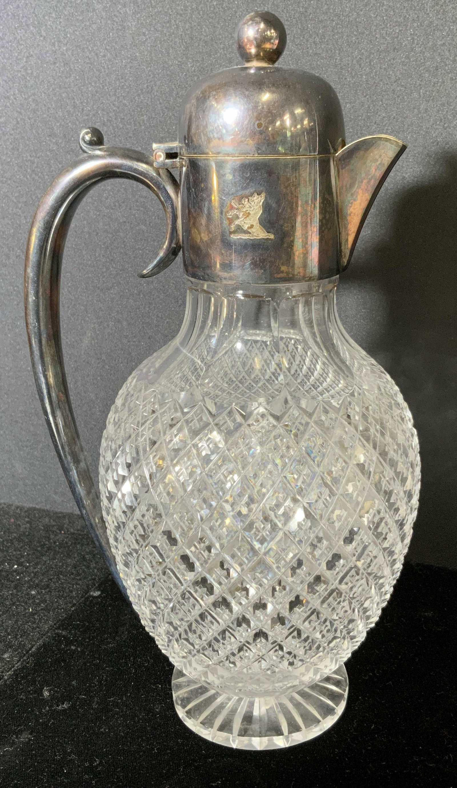 Cut Glass Cruet w Metal Cap: Cut glass cut. Decorated with cut reticulated pattern, scalloped neck. Metal cap and handle, marked RN, etching depicting a hoofed animal with an arrow in it. Possibly silver plated. Wear is consisten