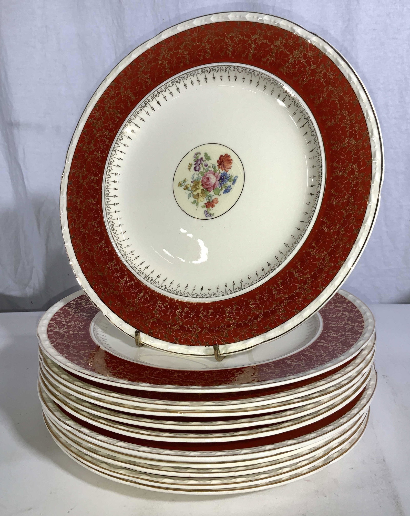 Set 11 Crooksville China Dinner plates: Porcelain dinner plates, cream toned with Hand painted with gilt on rust orange border rim and center floral medallion. 10.5 in. Stamped and signed Crooksville China Co 135 American Made. China ware, 