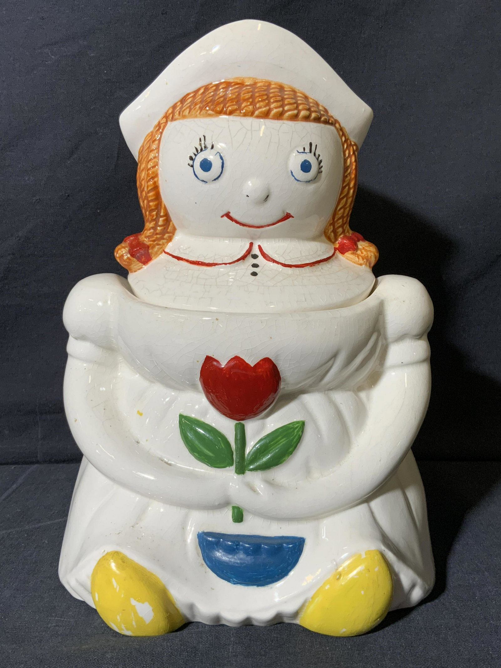 Ceramic Milk Maid Cookie Jar: Ceramic Milk Maid Cookie Jar, marking to underside reads â€˜Japanâ€™, subject a seated milk maid like woman holding a flower, measures 10 x 7 x 6 inches, surface wear to piece. Artwork, fine 
