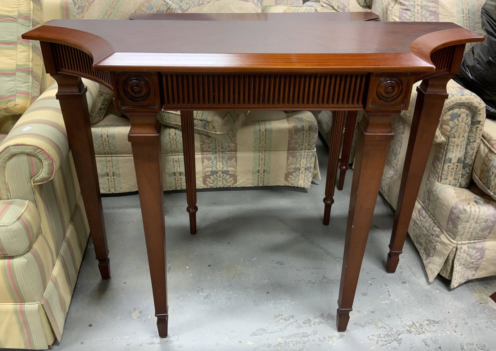 BOMBAY Wooden Entryway Table: Underside of table has tag which reads BOMBAY. Piece is mahogany toned and wooden. Piece has 1 drawer. Table measures approx 32 inches tall, 43 inches long, 15 inches deep. Bombay furniture, entry tab