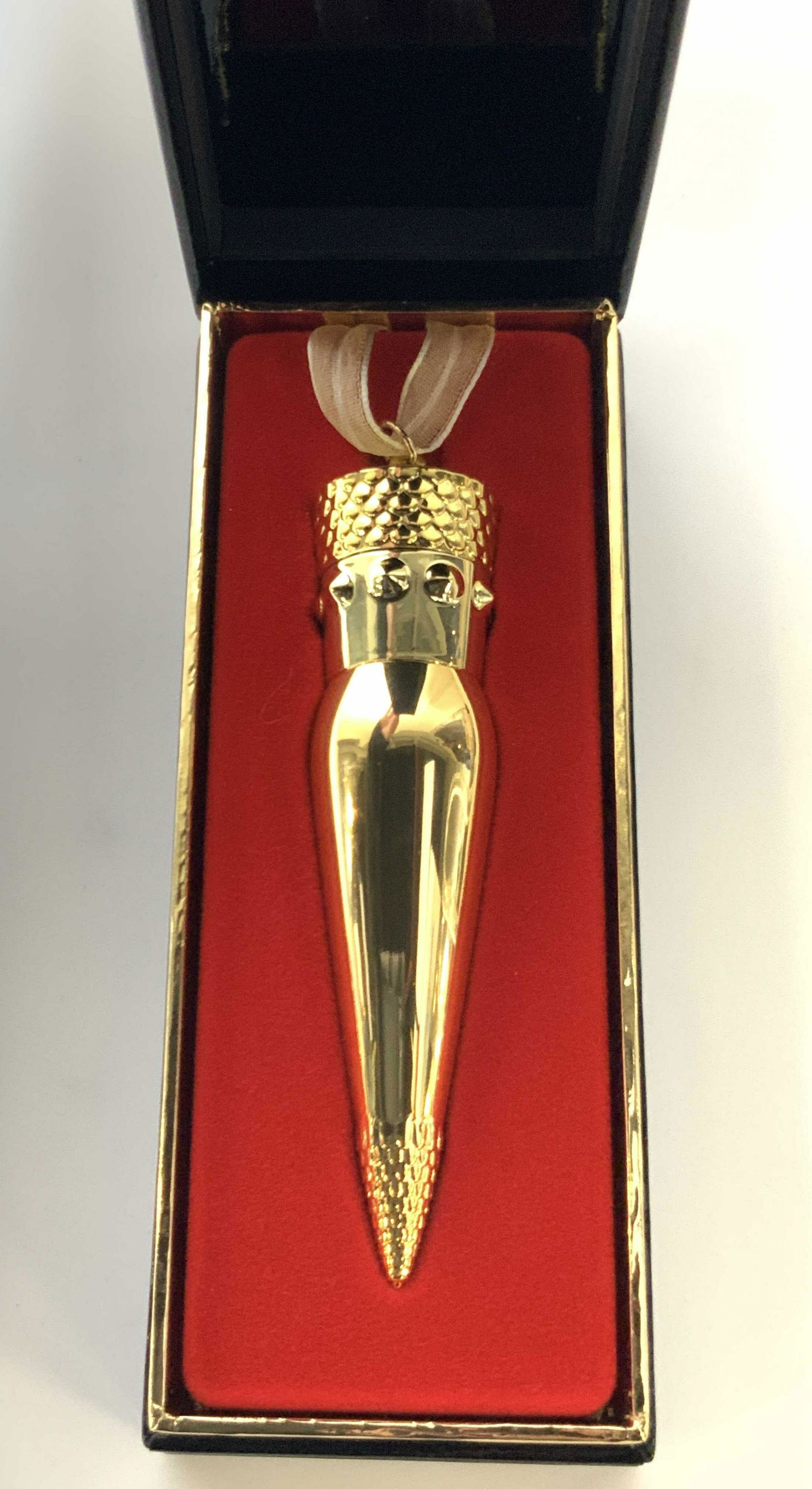 Christian Louboutin Silky Satin Lipstick , Org Box: Silky Satin Lip color by Christian Louboutin, in original casing and black box with black draw string bag. Lipstick case in a gold toned metal with removable cap that has a lace ribbon attached for we