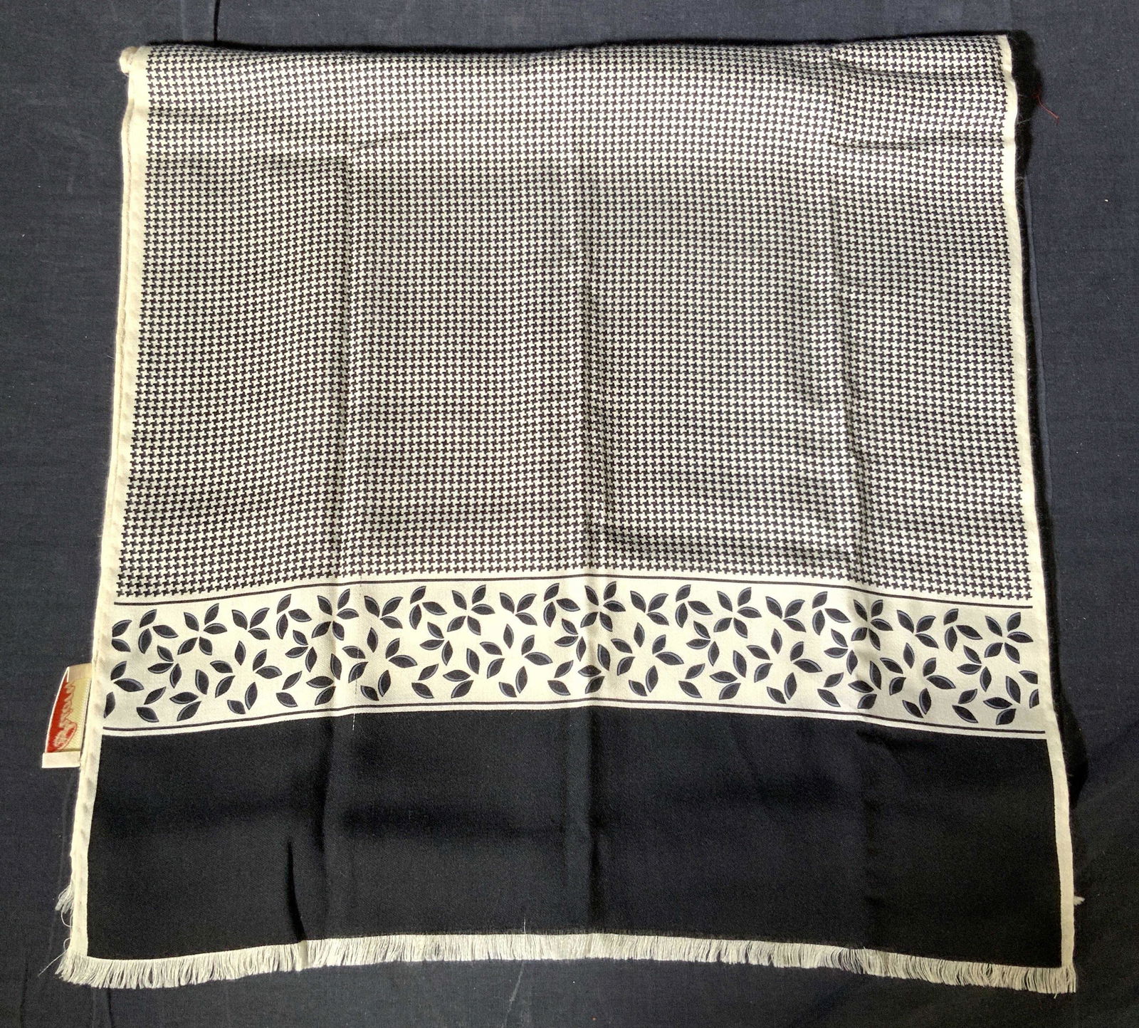BRIONI Hounds Tooth Cashmere Scarf: A Cashmere scarf by BRIONI, with hallmark on one corner. Scarf consists of a black and white hounds tooth pattern throughout scarf with a band of black floral design and a black band on each end with