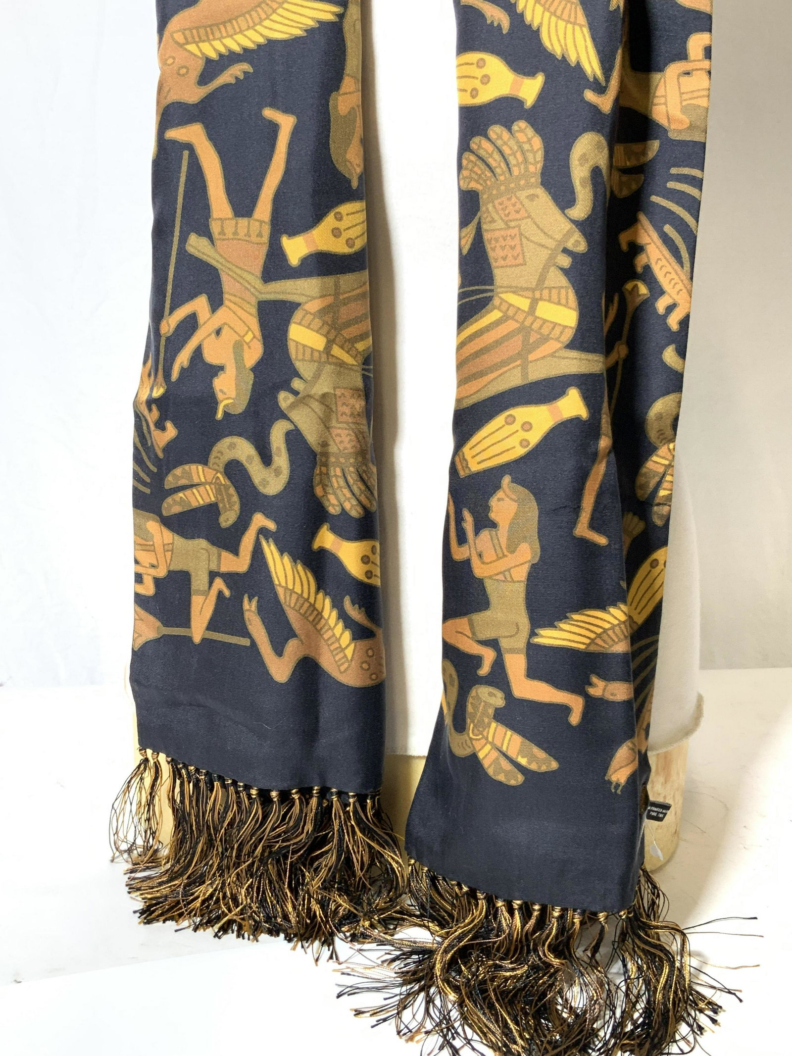 PAUL STUART Pure Silk Egyptian Fringe Scarf: Womenâ€™s silk Fringe scarf with tags marked Paul Stuartâ€™ and â€˜Hand printed in England, Pure silk the scarf has a black base tone with Images that resemble Egyptian hieroglyphics mad
