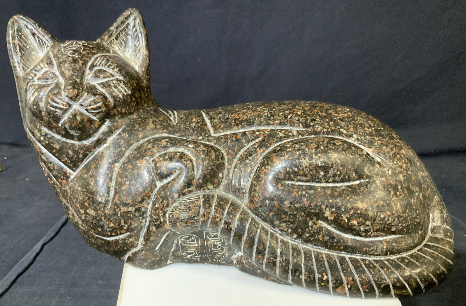 Natural Stone Cat Sculpture: Carved from stone and smooth to a polish, possibly granite, Is this cat in sitting position. detailed facial features of eyes and lashes, whiskers. has Egyptian style markings and markings of insect o