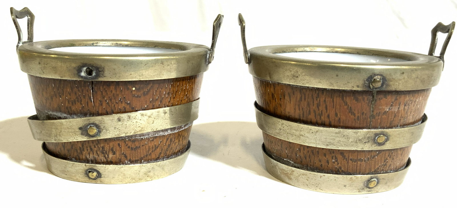 Pair Bentwood, Brass & Porcelain Salt Cellars: Salt cellars appear to be bentwood, porcelain, & possibly brass. Each piece is inscribed 1802. Salt cellars have barrel/ basket shape with metal handles on each side. Each measures approx 2.5 inches w