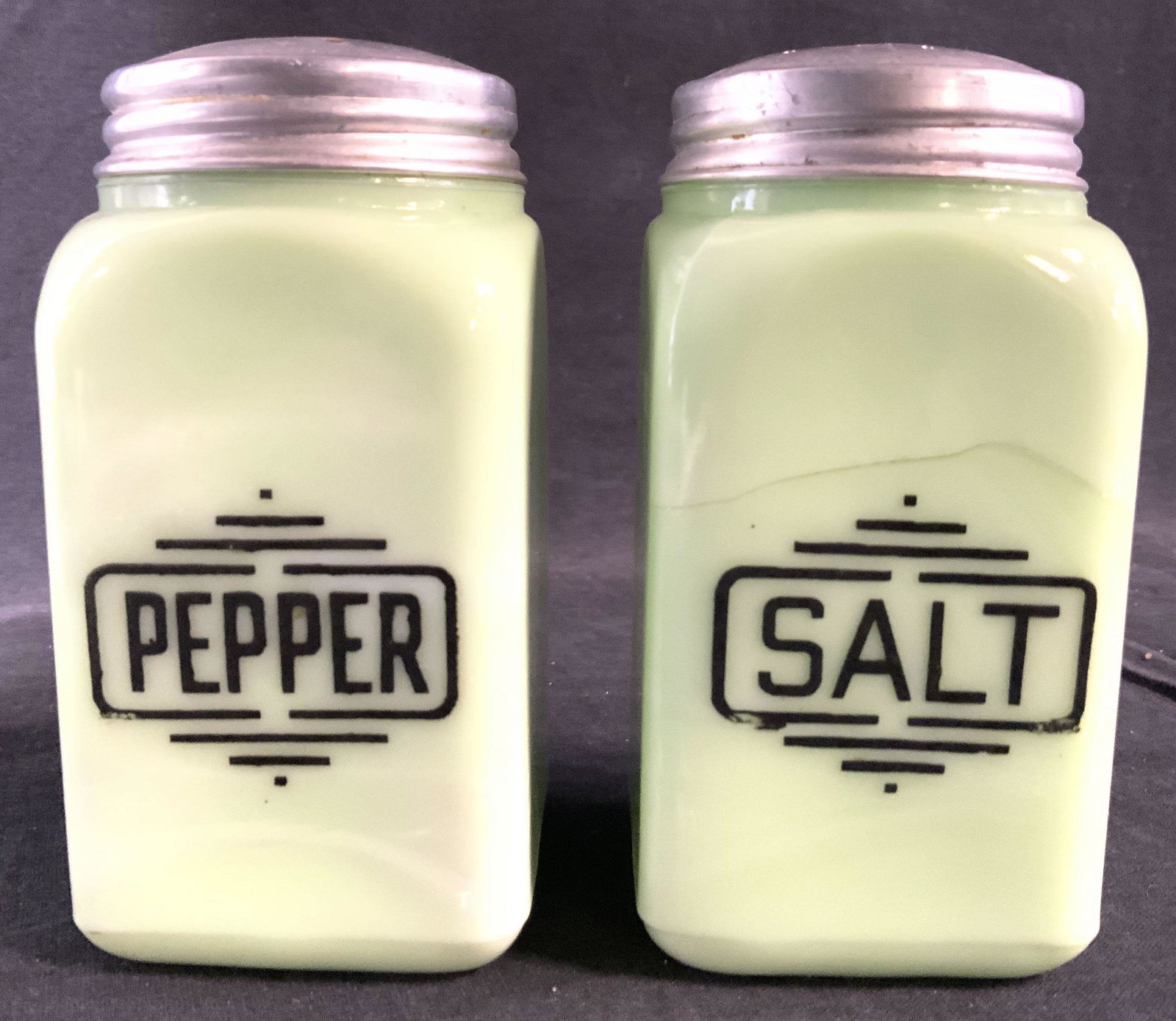 Pair Glass Salt & Pepper Shakers: Lot includes 1 salt & 1 pepper shaker. Each piece is seafoam green toned with black lettering. Tops of each shaker are silver toned and metal. Each piece measures approx 4.75 inches tall 2.5 inches wi