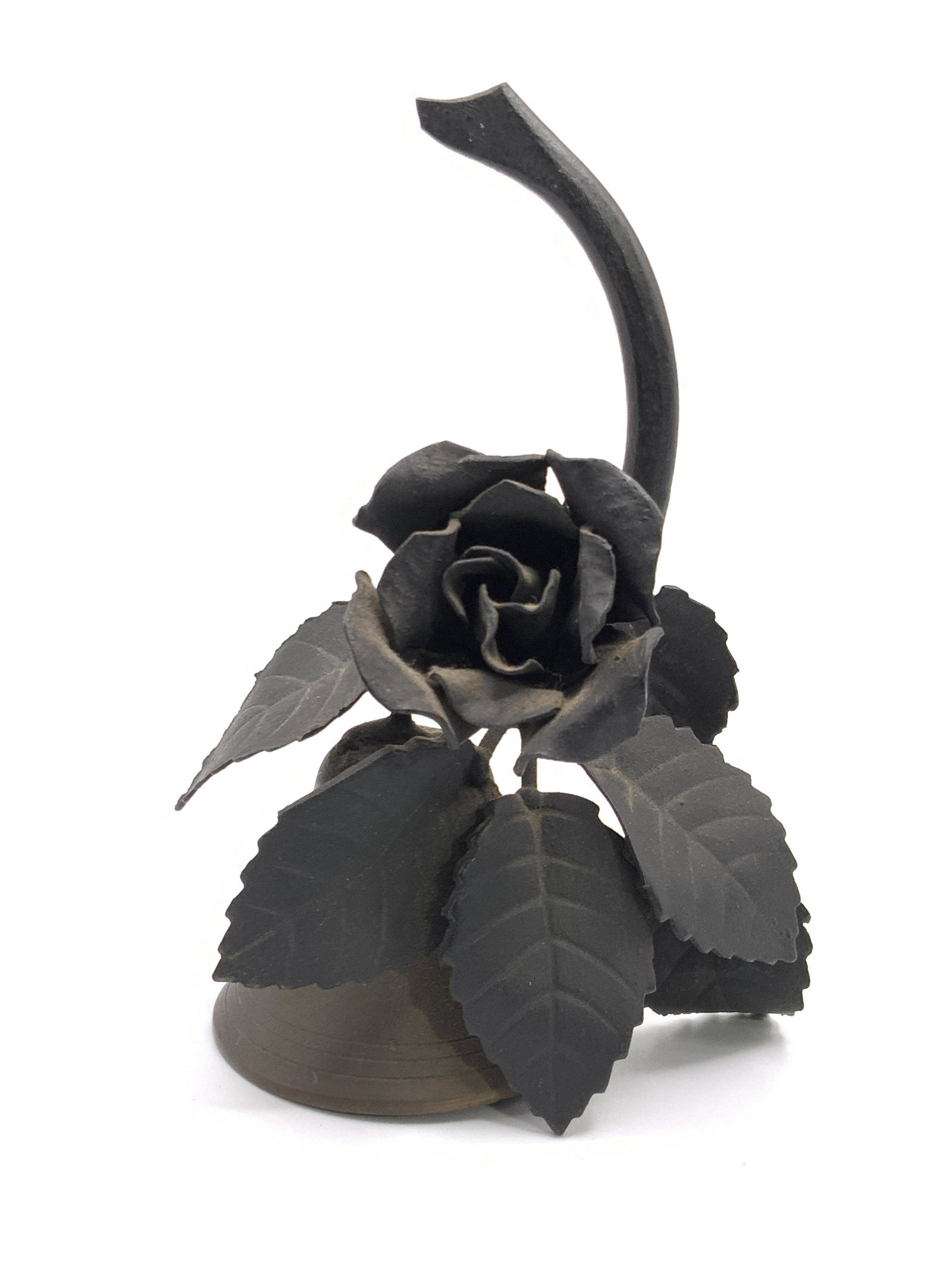 Vintage Metal 3D Rose Motif Bell: A collectible vintage metal rose motif bell. Dark, nearly black hued 3D metal rose sits atop a bronze hued bell. Bell ringer / clapper to interior. Measures approx 5.25H x 3W in. Some wear consistent 